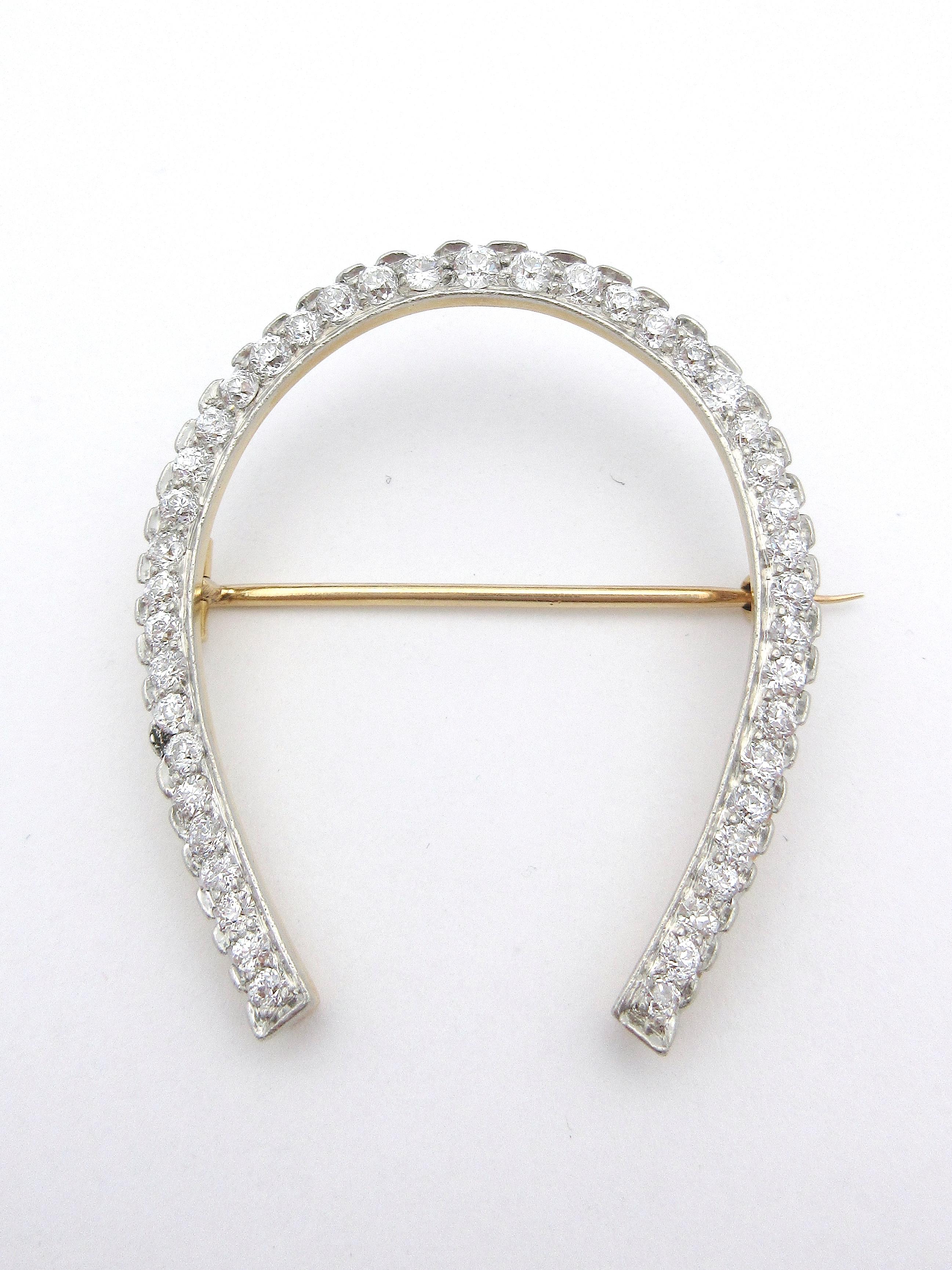 This exquisite brooch by Tiffany & Co is from the early 1900s and depicts a horseshoe set with European cut diamonds.  The platinum-topped, 18k yellow gold brooch contains just over 2cttw of G color, VS clarity diamonds.  It measures approximately