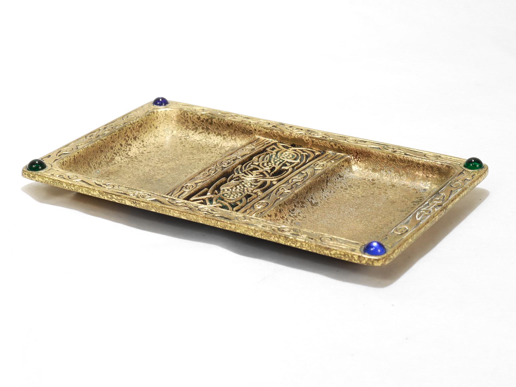 By Tiffany & Co.

In the 'Ninth Century' pattern.

Divided with 2 sections and blue and green glass cabochons to the corners.

Marked to the base Tiffany & Co. / Makers / 142.

Simply a wonderful tray!

Date:
Early 20th Century

Overall