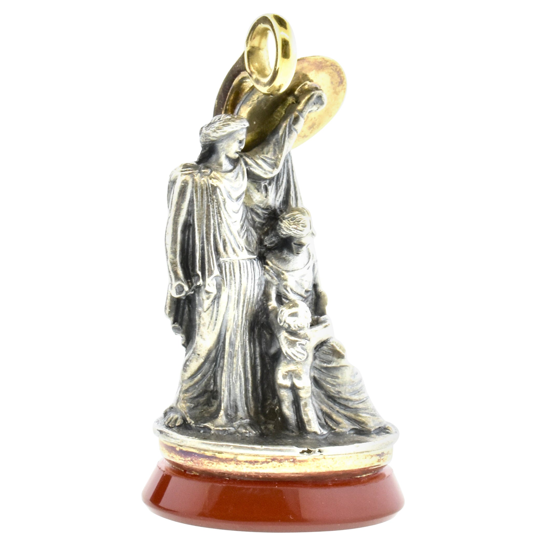 Tiffany & Co antique pendant/fob depicting Perseus son of Zeus, slayer of Medusa and protector of the Good (in this case a mother and child).  He is shielding them from the rigors of life in this world.
Silver, gold and a virgin carnelian seal, this