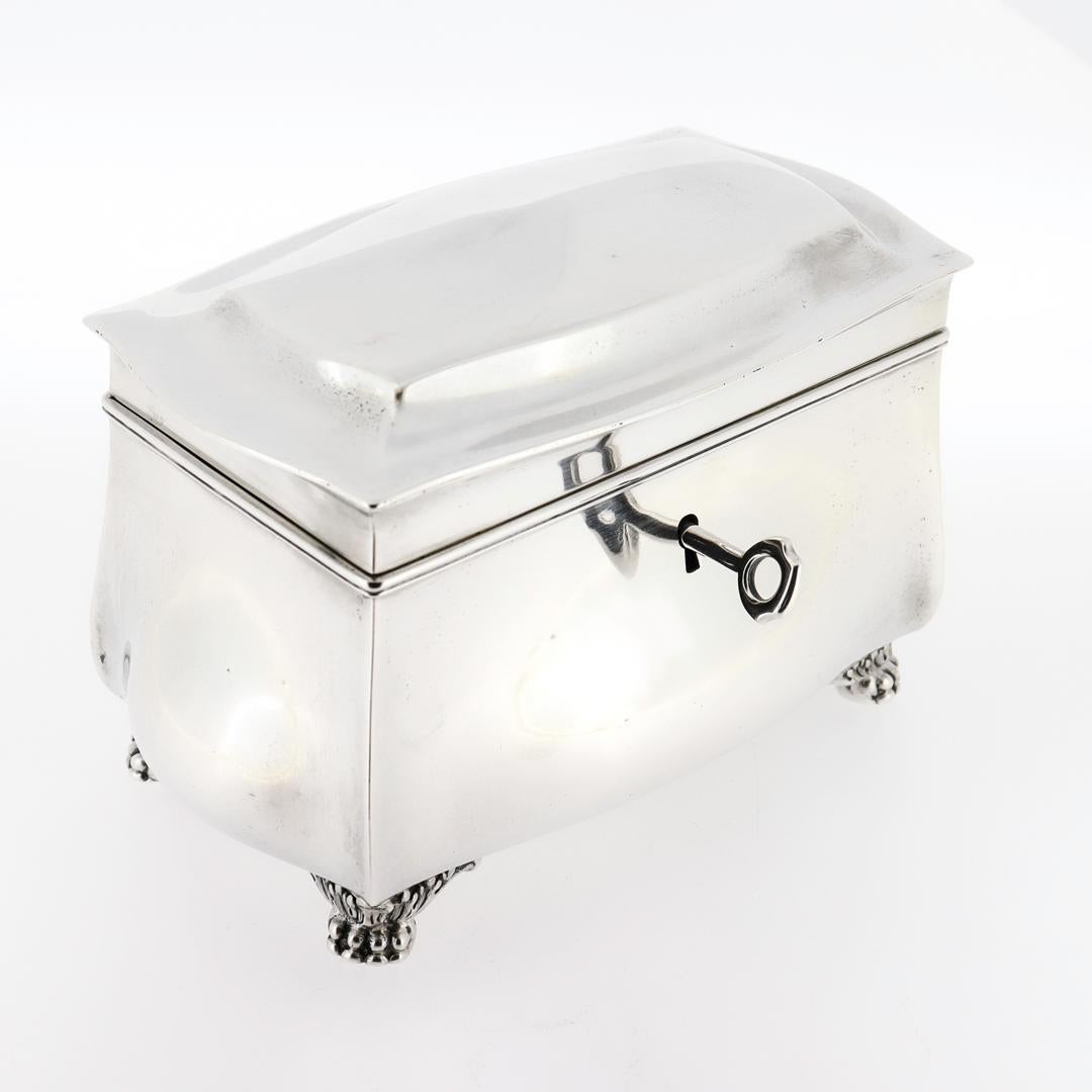 A fine antique Bombay shaped table box or casket.

By Tiffany & Co.

In sterling silver.

With a hinged lid that opens to reveal a gilt compartment under glass and gilt interior, a baluster form body, and squat hairy paw feet.

With its original
