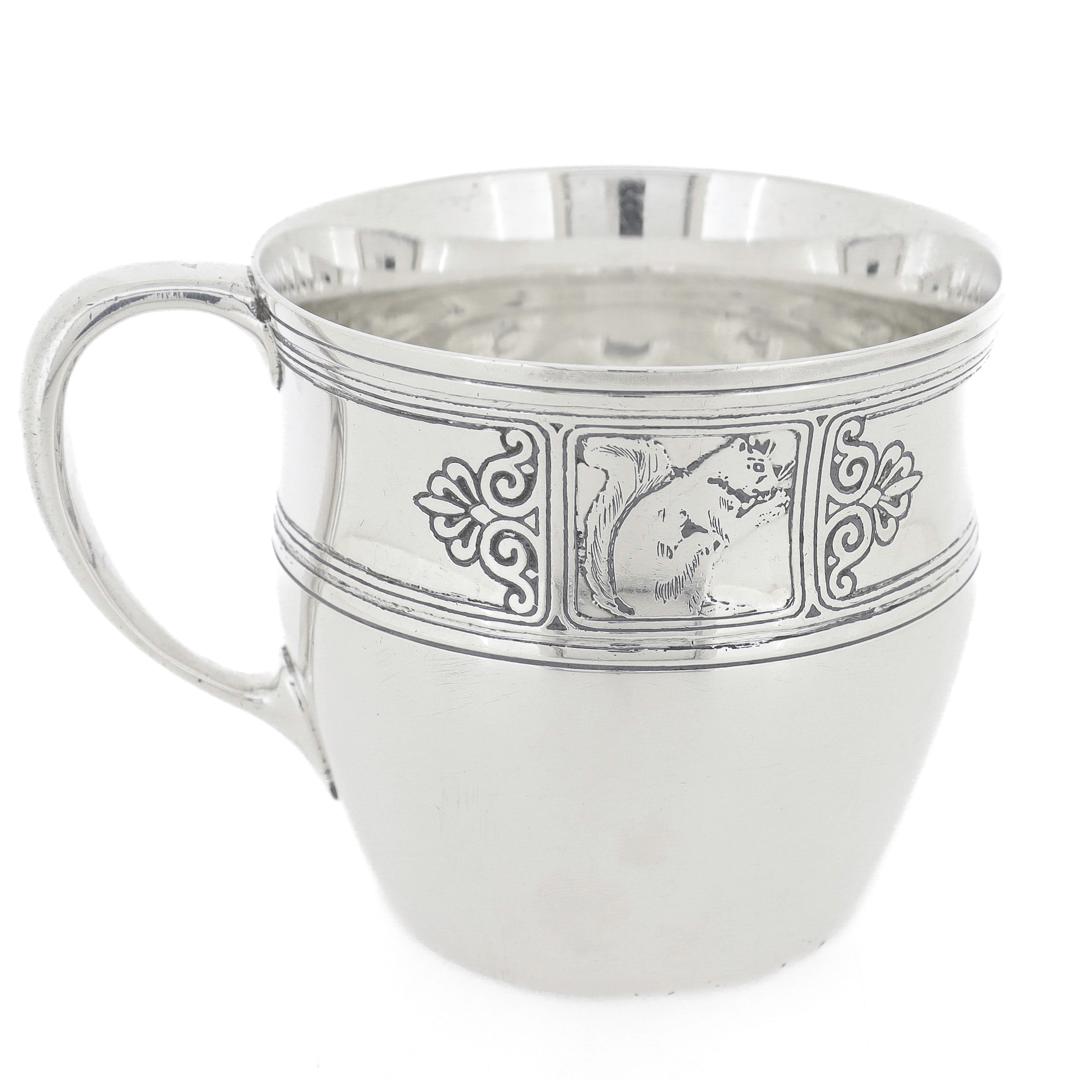 A fine antique child's mug.

By Tiffany & Co.

In sterling silver.

With acid etched decoration and cartouches with a squirrel on one side and a bird (possibly a kingfisher) to the reverse.

Fully hallmarked to the base.

Simply a wonderful Tiffany