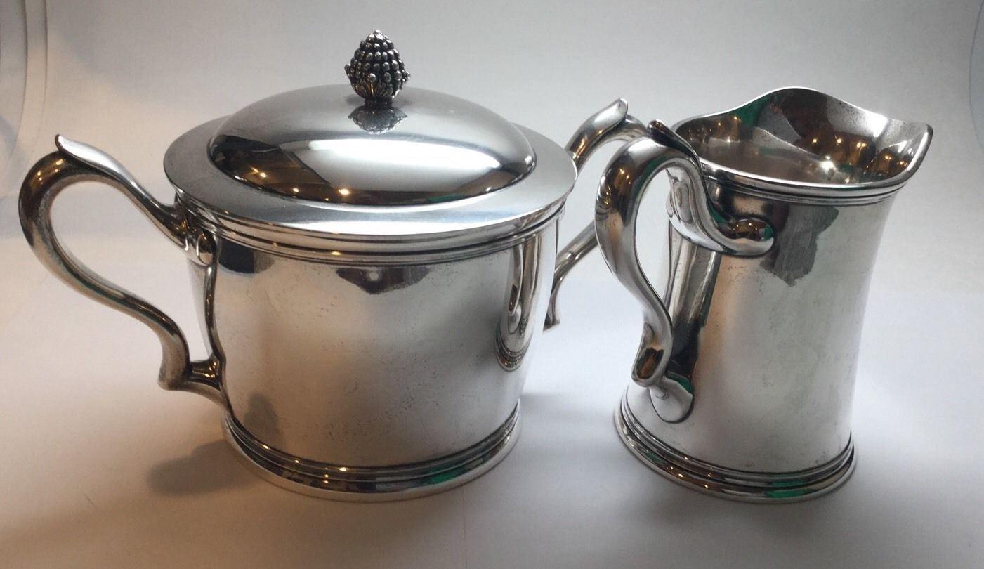 Antique sterling silver lidded double handle sugar bowl and creamer by Tiffany & Co.
Berry finial on sugar bowl lid

Circa 1880 - 1881 according to pattern #5962

Scrolled monogram ALC June 8th, 1881
 Total weight 944.2 grams, 607.1 penny