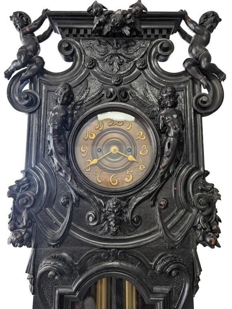 Monumentale viktorianische Uhr mit geschnitztem Gehäuse von Tiffany & Co. um 1880. Eine Kombination aus C- und S-Rollen entlang der Glastür, die von Putten flankiert wird. Der Sockel ist mit Grotesken und weiblichen Büsten beschnitzt, die auf einem
