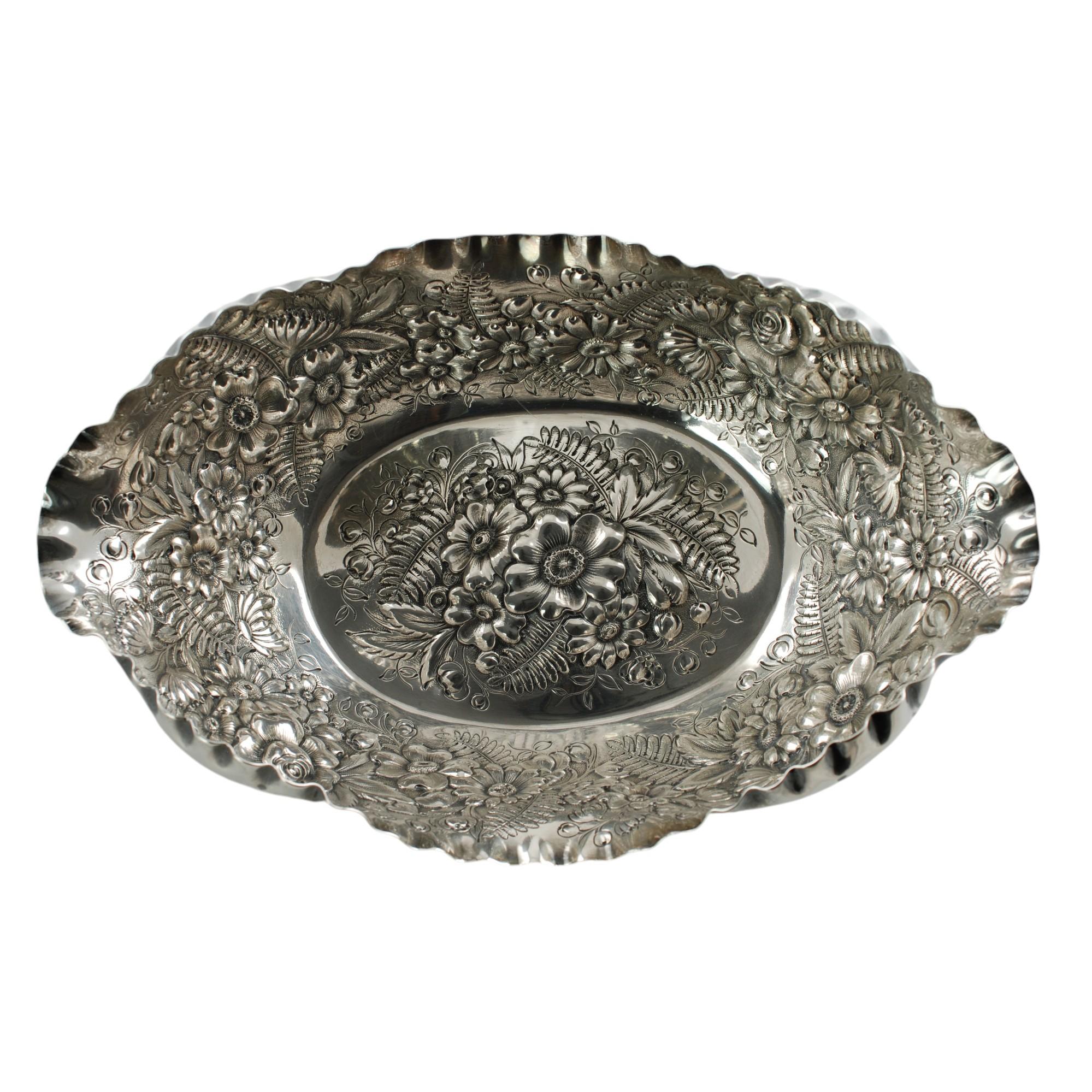 Cette élégante coupe en argent sterling de la fin du XIXe siècle a été fabriquée par Tiffany & Company. Le bol en argent est de forme ovale et l'intérieur est orné d'un décor repoussé en forme de fougères et de fleurs. Le bord du bol a un bord