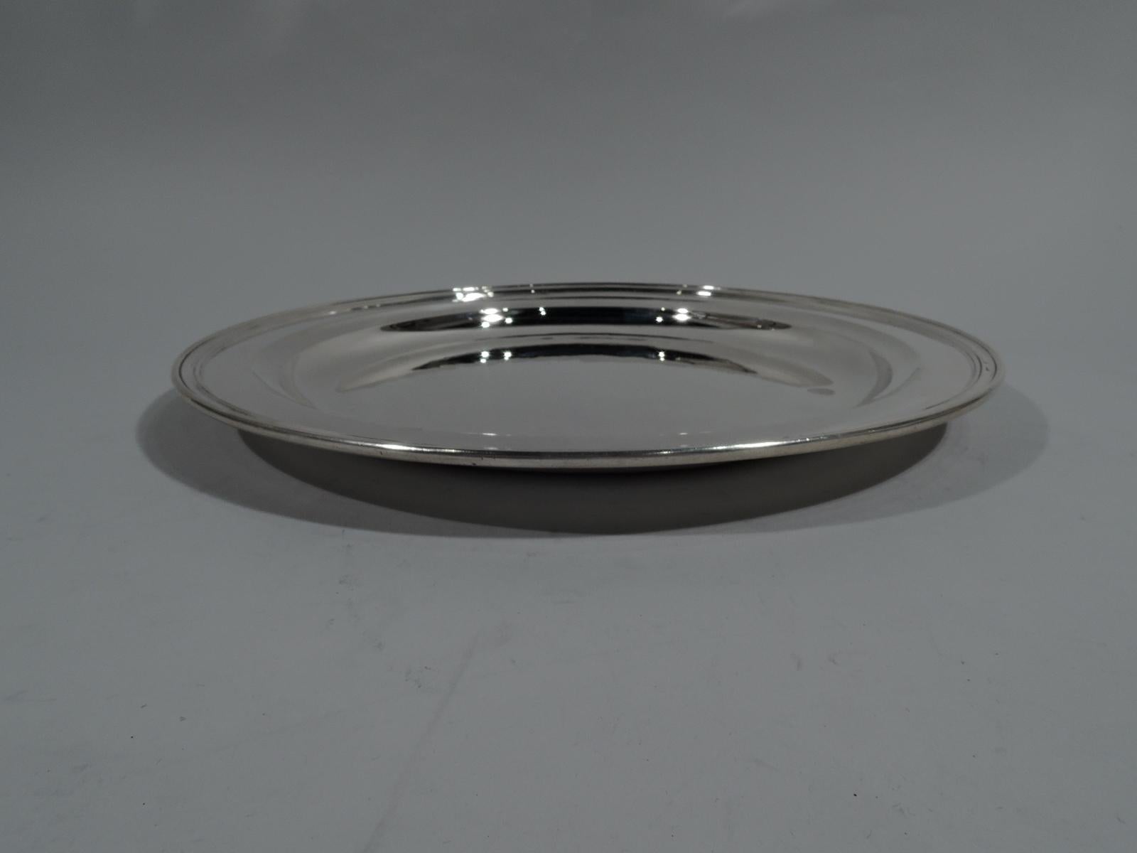 Deep and heavy sterling silver serving tray. Made by Tiffany & Co. in New York, circa 1910. Round well, tapering shoulder, and molded rim. Fully marked including pattern no. 11742C and director’s letter m (1907-47). Weight: 30.5 troy ounces.