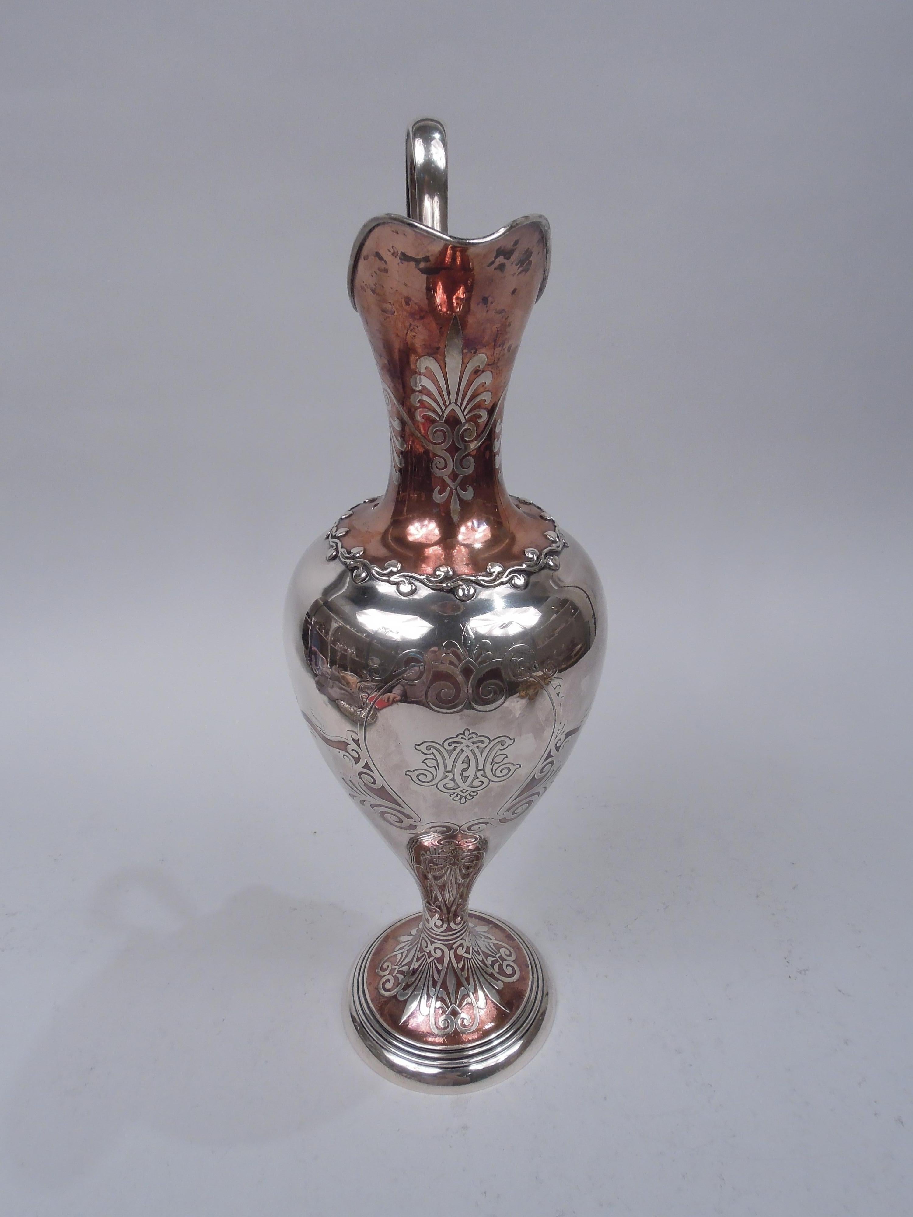 Edwardian mixed metal sterling silver ewer. Made by Tiffany & Co. in New York. Helmet mouth with high looping leaf-mounted handle; ovoid body on domed foot. Mouth, neck, and foot have copper ground. Applied meandering border on shoulder. Acid-etched
