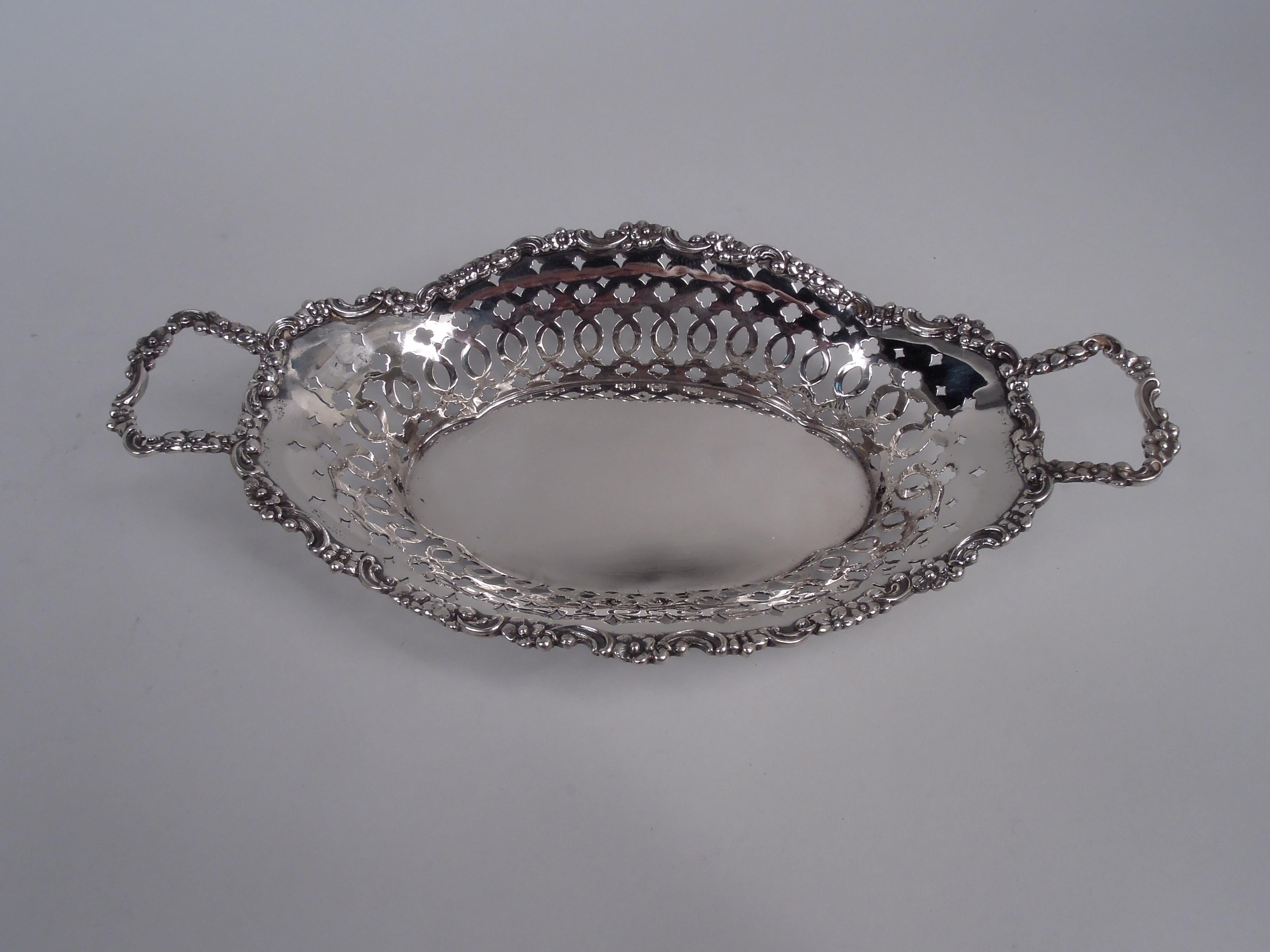 Bandeja clásica eduardiana para el pan, de plata de ley. Fabricado por Tiffany & Co. en Nueva York. Pozo macizo ovalado y lados ahusados con perforaciones ornamentales. Asas de extremo de ménsula de fundición con volutas y flores. Borde ondulado