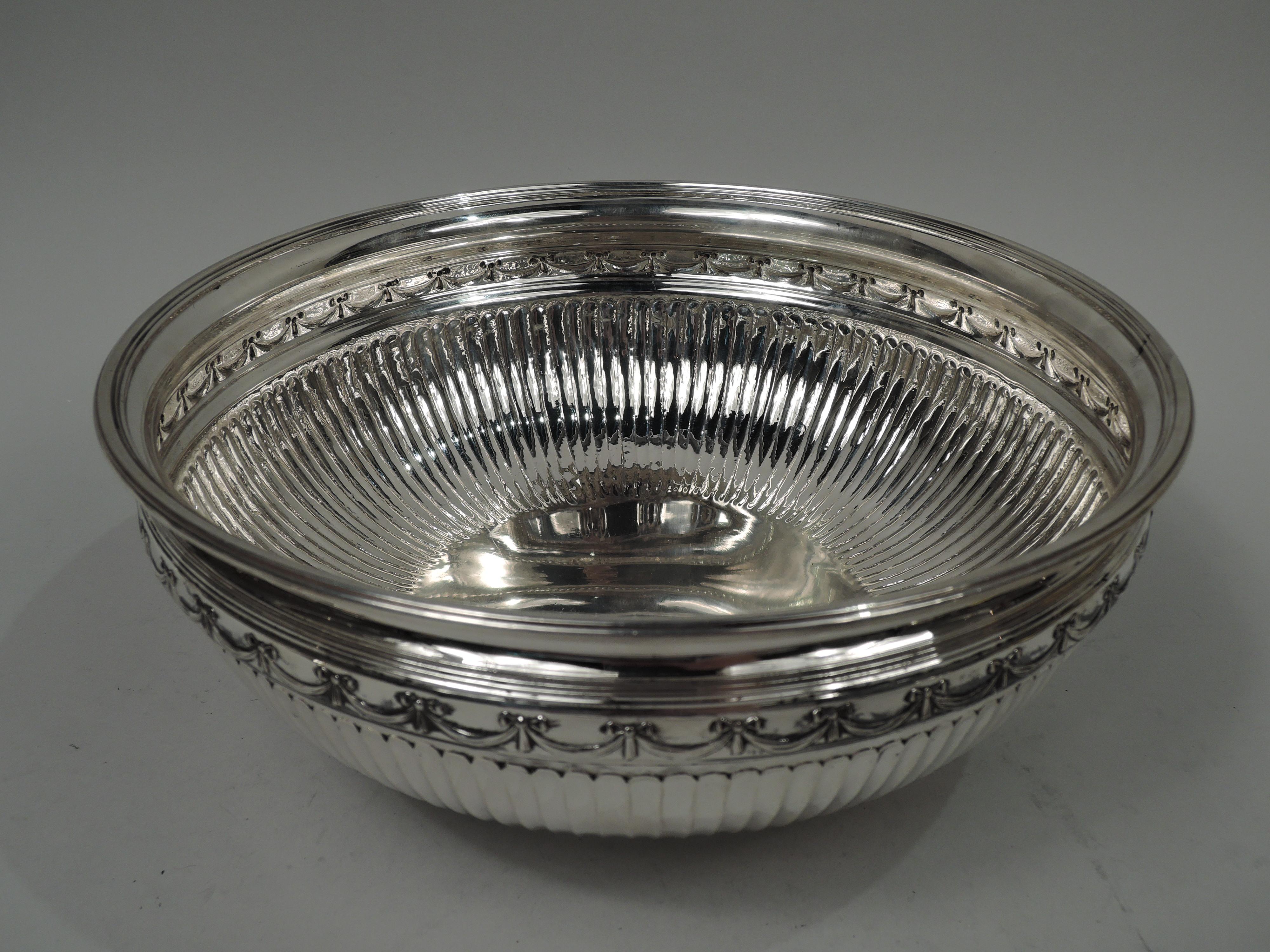 Edwardian Classical sterling silver bowl. Made by Tiffany & Co. in New York, ca 1910. Flared rim and curved and fluted sides below chased swag border; stepped and inset foot. Reeding. Fully marked including maker’s stamp, pattern no. 48319, and