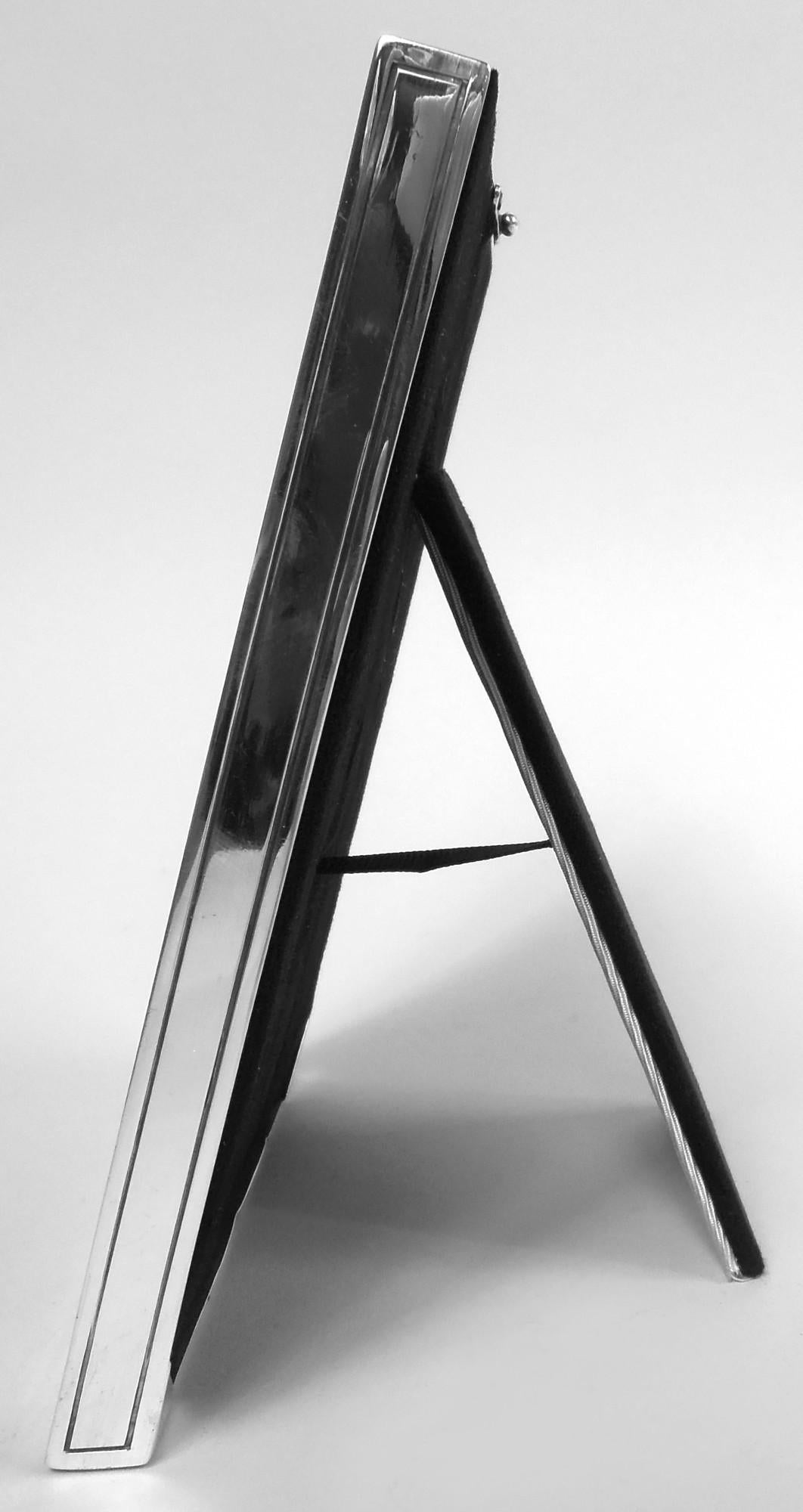 Edwardian Classical sterling silver picture frame. Made by Tiffany & Co. in New York, ca 1910. Rectangular surround with acid-etched bead and patera border; sides have incised rectangular frames. With glass, silk lining, and velvet back and hinged