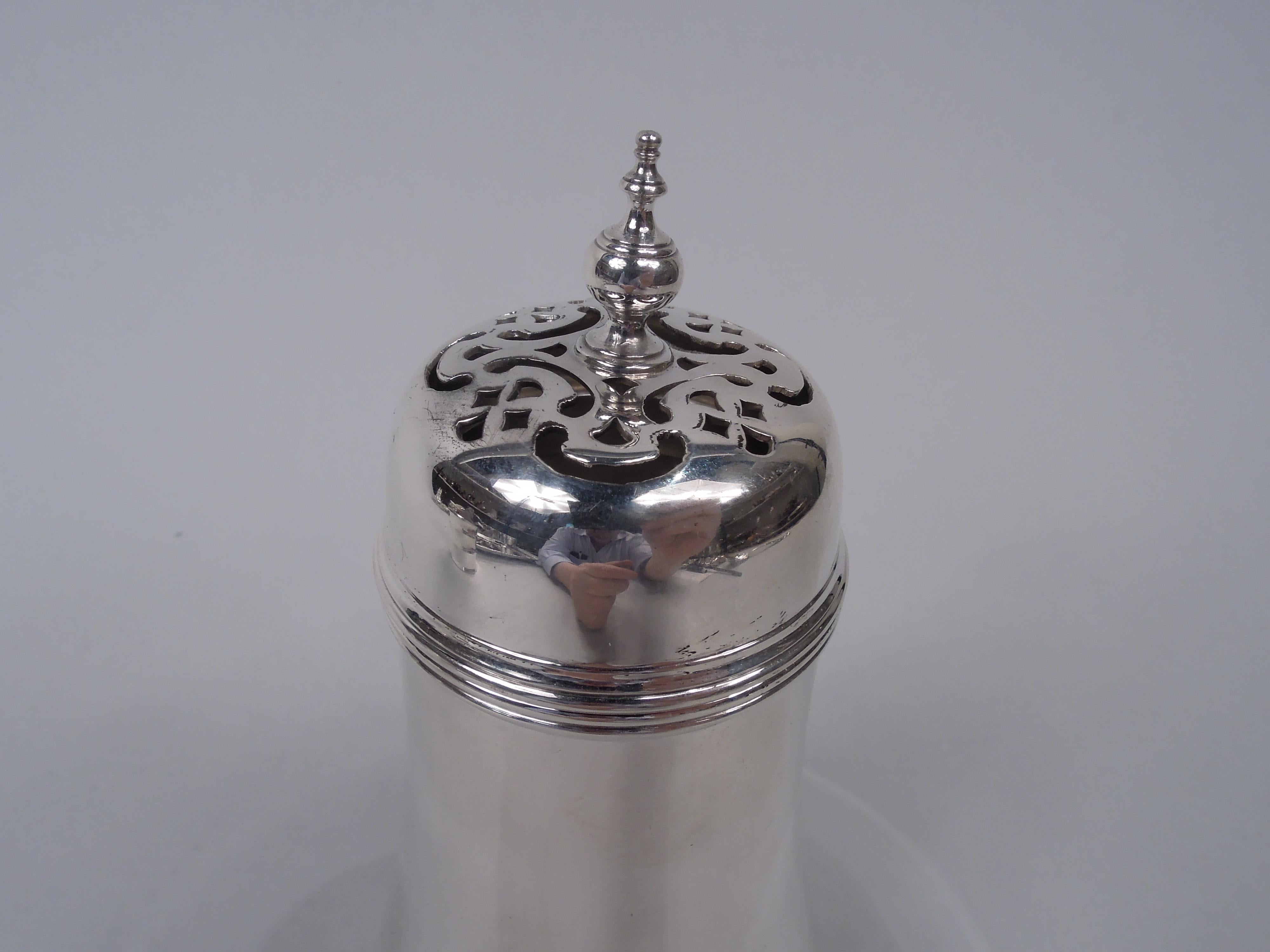 Edwardian Classical sterling silver sugar caster. Made by Tiffany & Co. in New York, ca 1909. Upward tapering bowl with reeding; stepped and spread foot. Cover domed with vasiform finial; top has ornamental piercing. Fully marked including maker’s