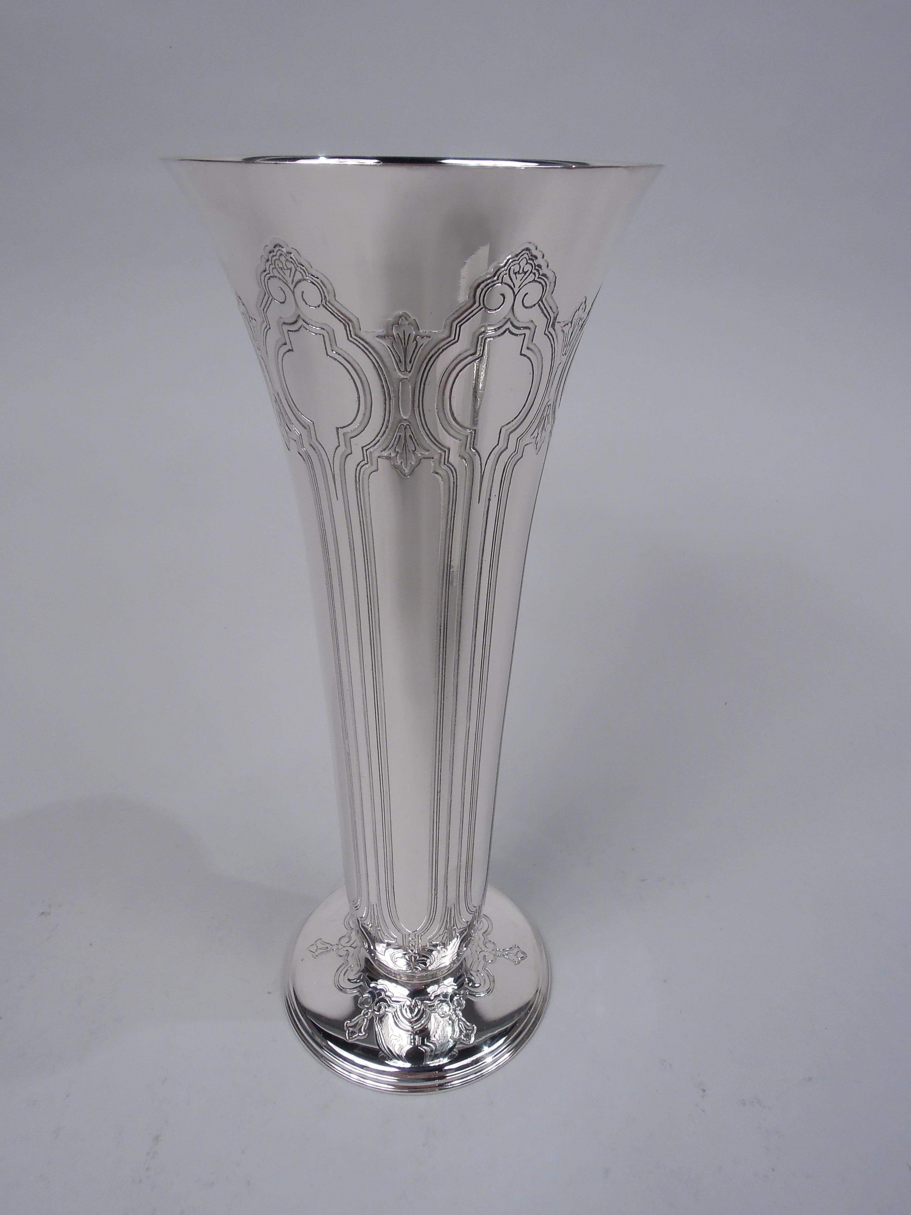 Edwardian Classical sterling silver vase. Made by Tiffany & Co. in New York, ca 1912. Tapering sides with flared mouth rim and stepped round foot. Acid-etched vertical ornament with alternating wide and narrow curvilinear frames with stylized leaves