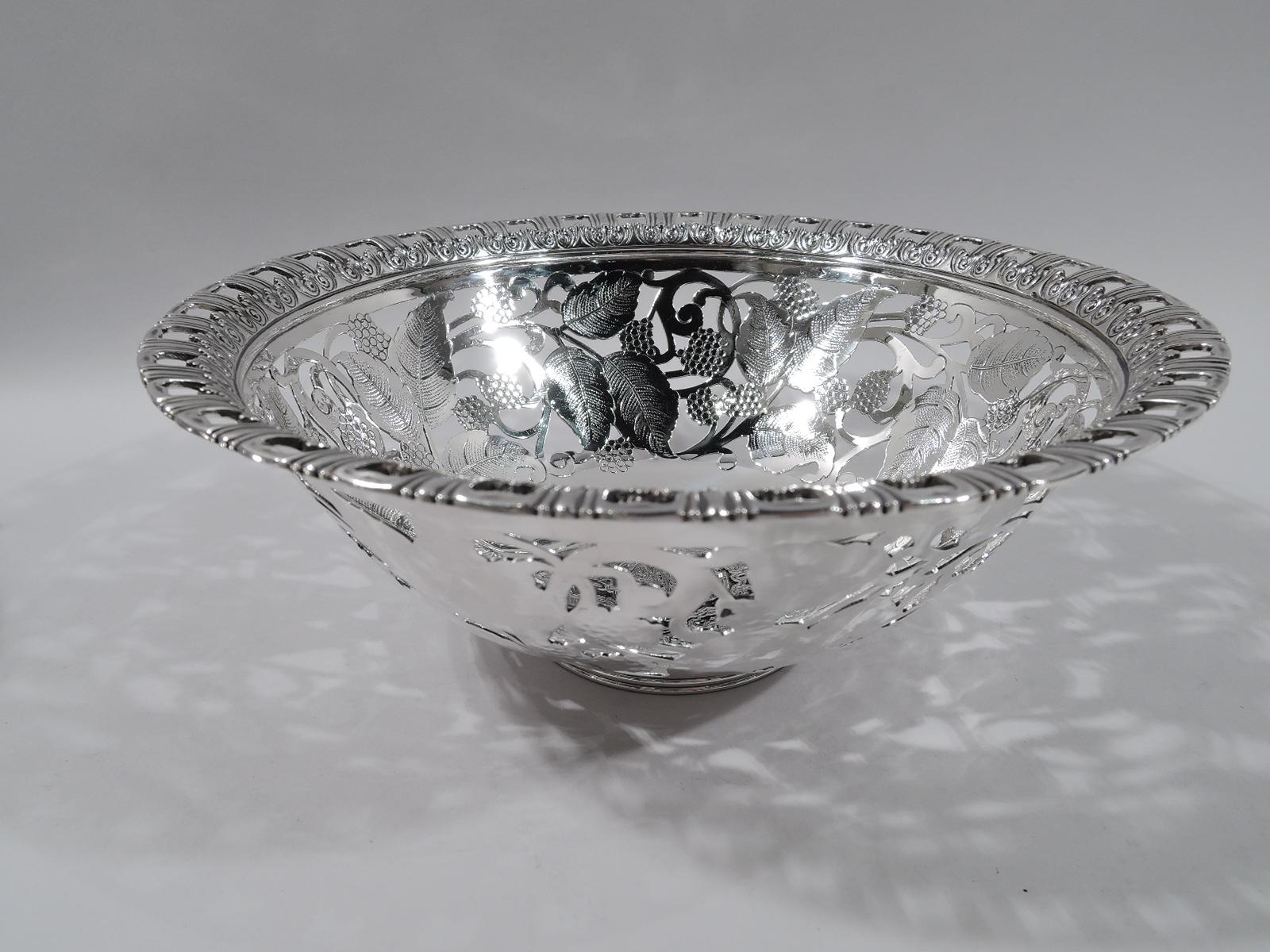 Edwardian sterling silver bowl. Made by Tiffany & Co. in New York. Round with solid well engraved with interlaced monogram in ornamental surround. Sides open and engraved with scrolling brambles. Pierced rim with leaf-and-dart and leaf borders.