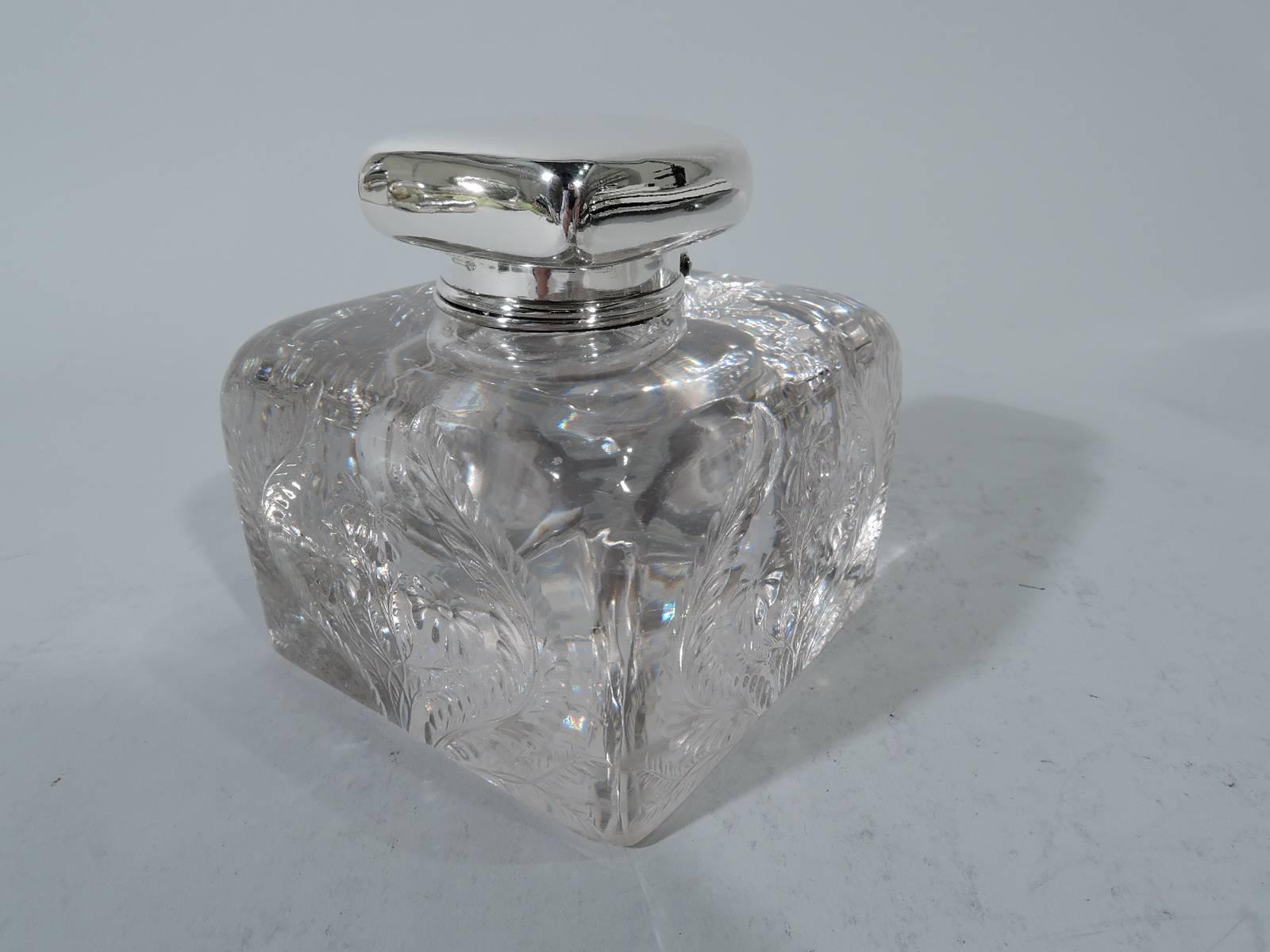 Edwardian glass and sterling silver inkwell. Made by Tiffany & Co. in New York. Rectilinear clear glass block engraved with ferns and flowers. Short neck has sterling silver collar with hinged square cover. Hallmark includes pattern no. 17360 (first