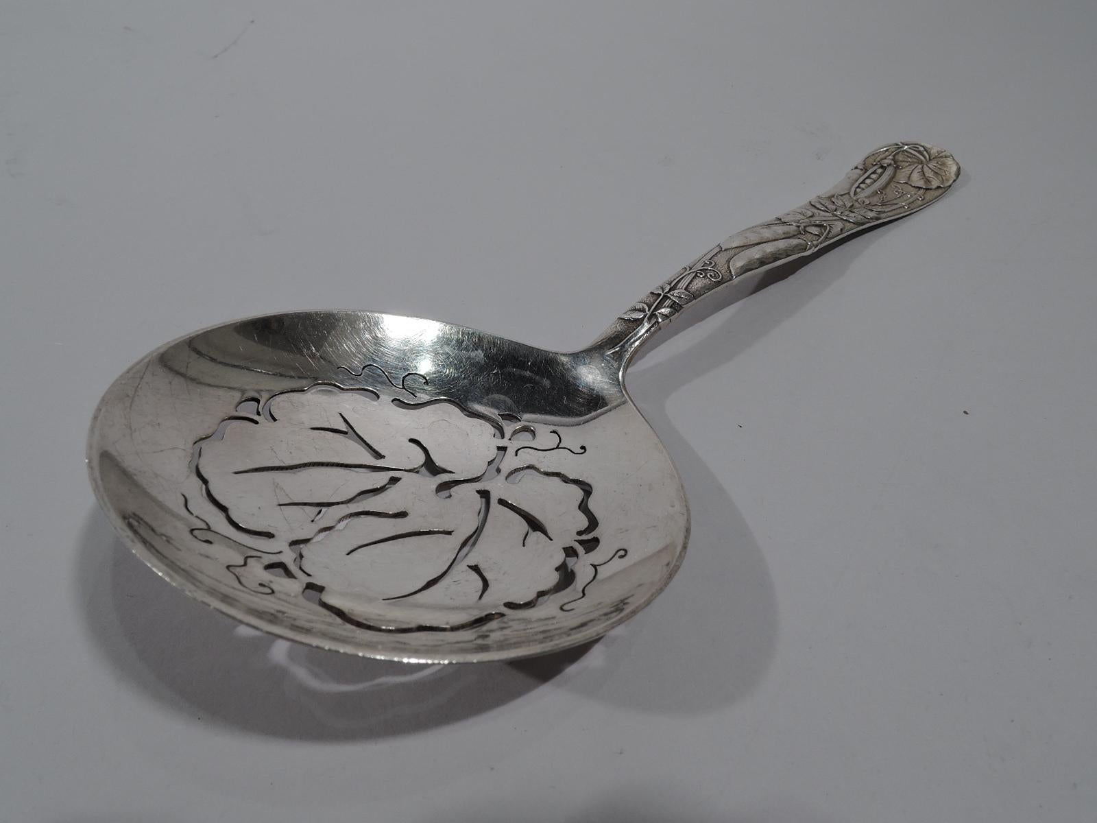 Very desirable sterling silver pea server in Vine. Made by Tiffany & Co. in New York. Tapering handle with loosely arranged wraparound pea pod vine on tapering and gently waving handle. Round bowl with pierced ornament in same motif. A beautiful