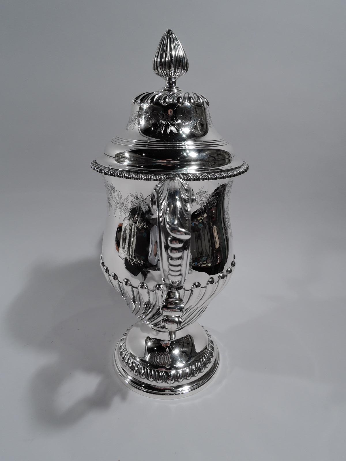 Georgian neoclassical sterling silver covered urn. Made by Tiffany & Co. in New York, circa 1913. Baluster body with leaf-capped double-scroll side handles and domed foot; cover domed with large conical bud finial and egg-and-dart rim. Twisted and