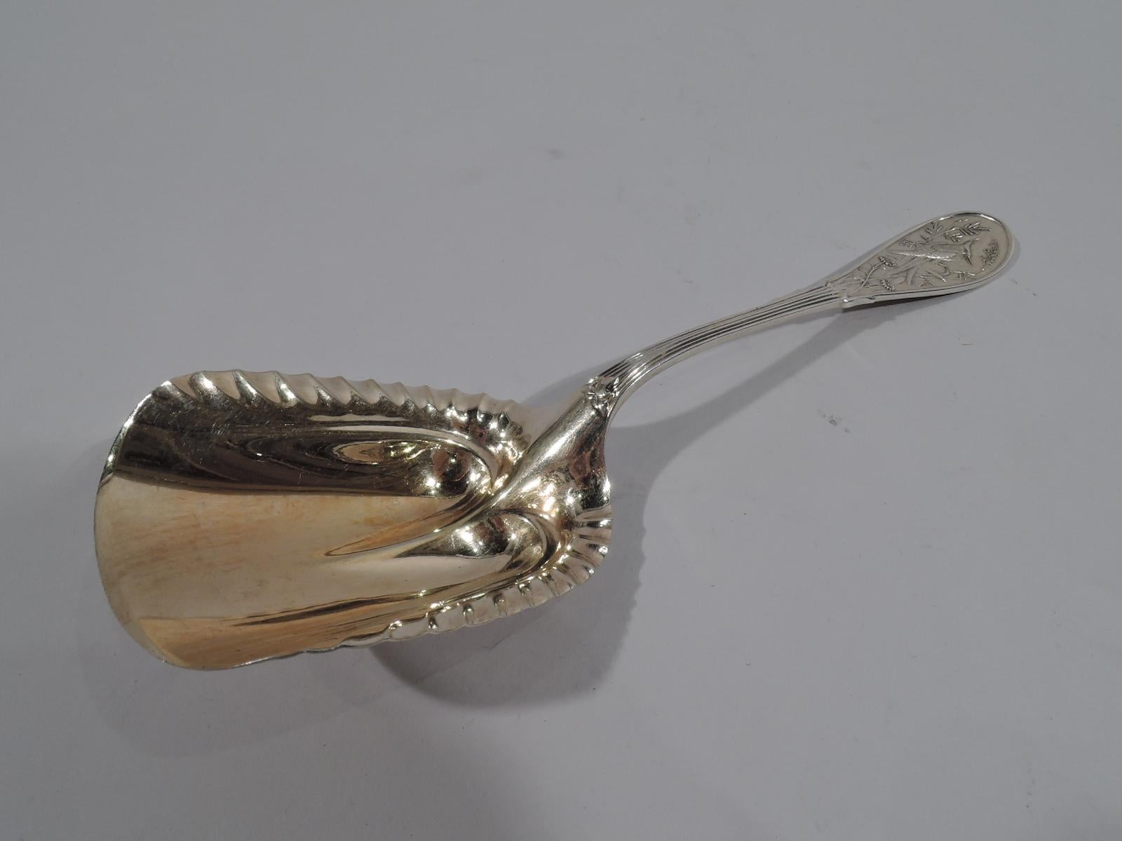 Aesthetic sterling silver berry scoop in Japanese. Made by Tiffany & Co. in New York. Raised handle with oval terminal. Double sided low-relief stylized ornament with perched bird, flowers, and leafing stalks. Gilt-washed lobed and crimped