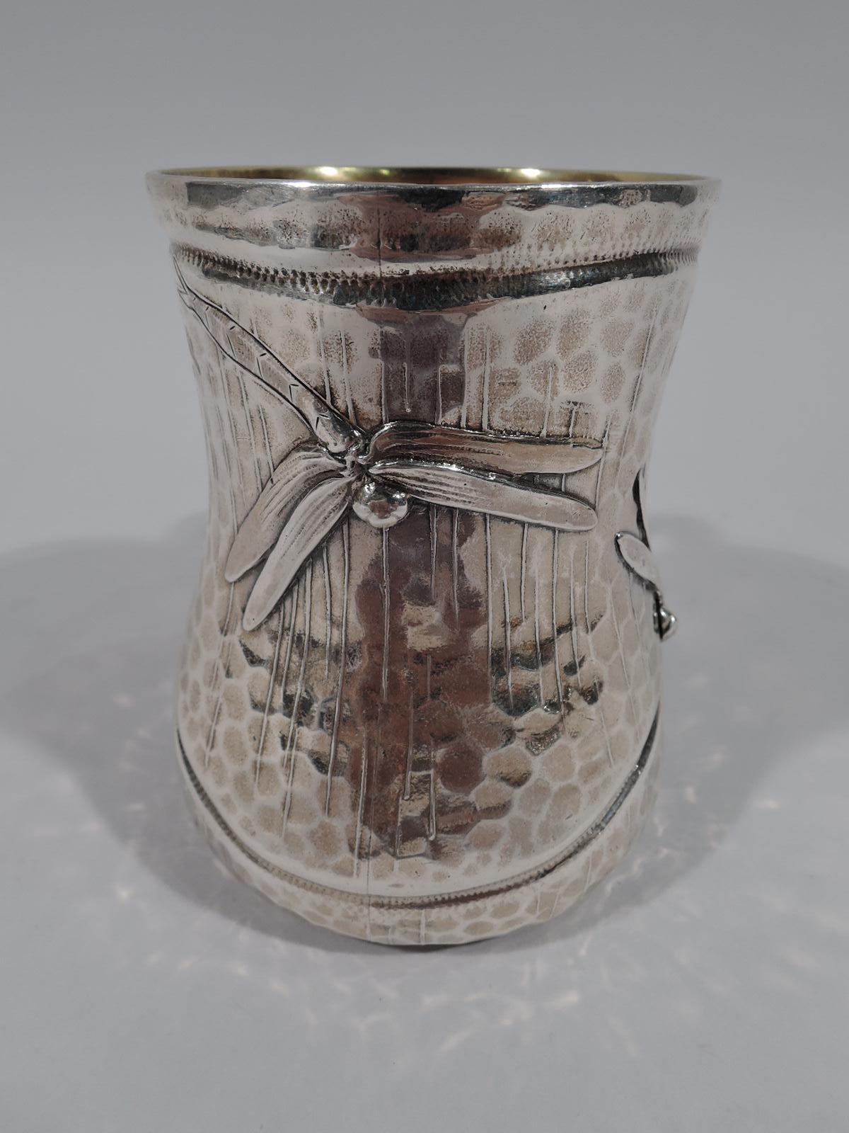 Japonesque sterling silver christening mug. Made by Tiffany & Co. in New York, circa 1879. Baluster with C-scroll handle. Acid-etched irregular striation on hand-hammered honeycomb ground. Three dragonflies with applied heads and wings tapering into