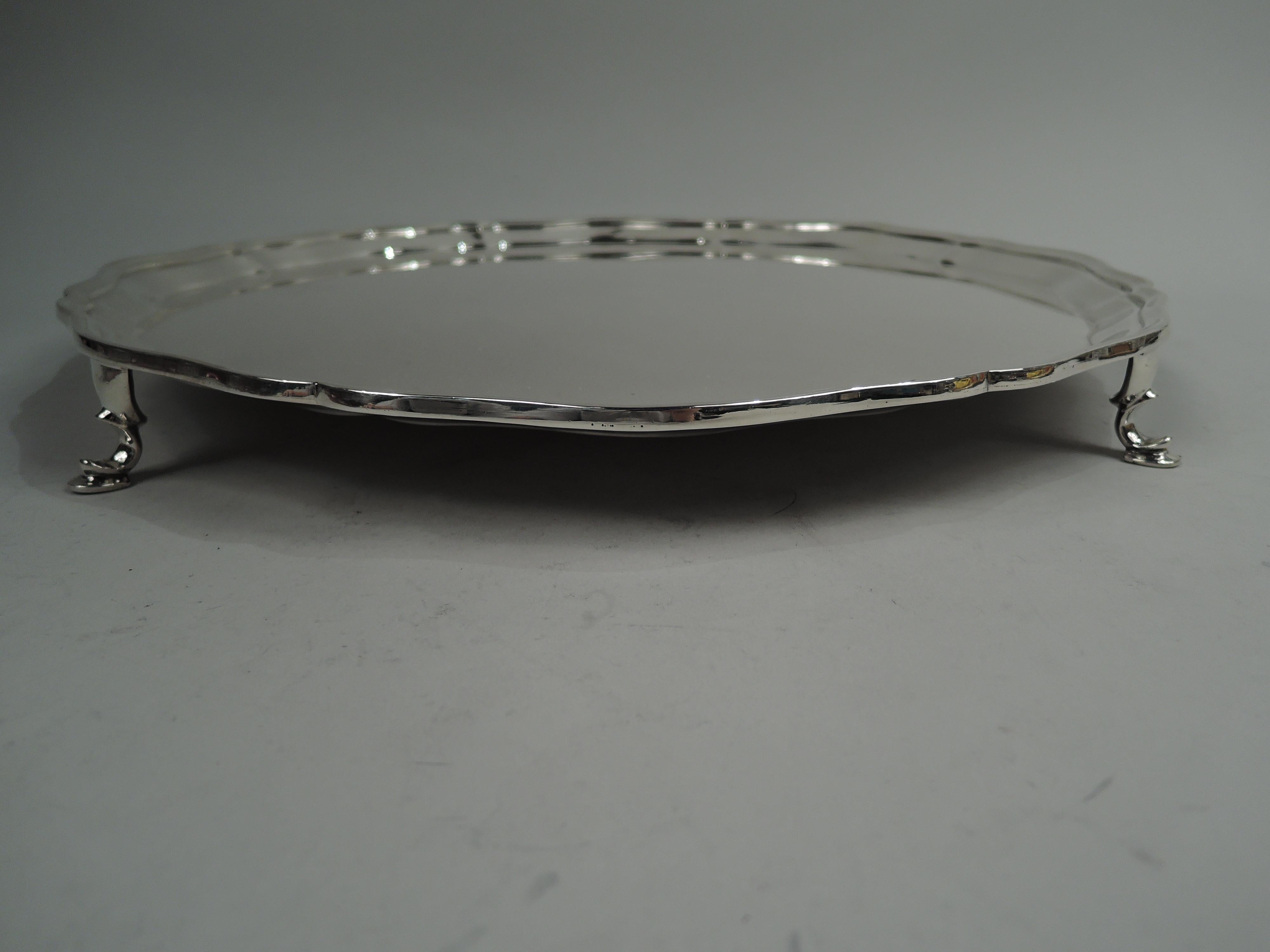 English Georgian sterling silver salver, 1926. Retailed by Tiffany & Co. in England. Round with molded serpentine rim. Four scroll-mounted hoof supports. Fully marked including maker’s stamp (Thomas Bradbury & Sons Ltd) and London assay stamp as