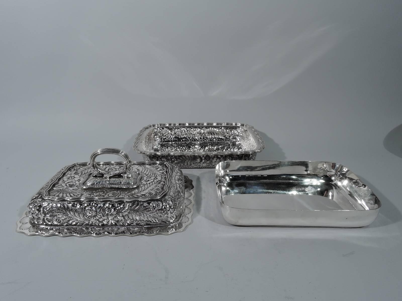 Sterling silver covered vegetable dish. Made by Tiffany & Co. in New York. Rectangular bowl with round corners and flat and wavy reeded rim and engraved striation. Cover raised with twist-lock leaf-mounted reeded ring handle and flat wavy rim with