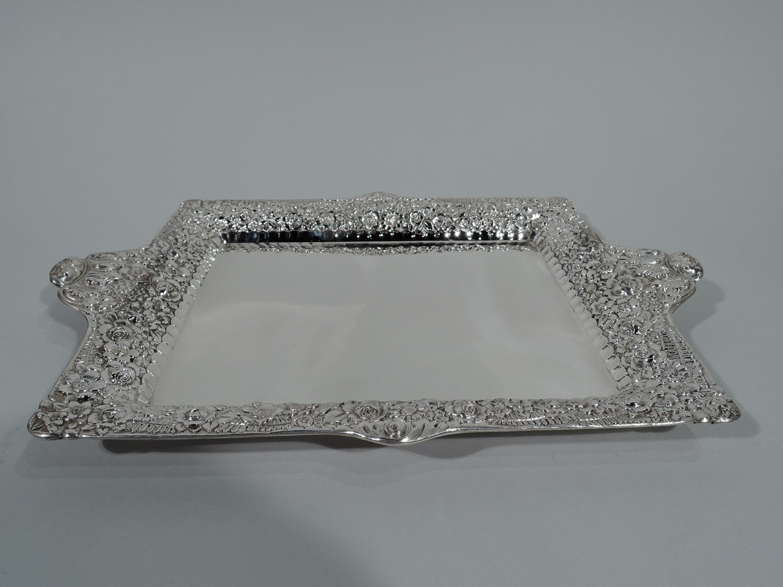 Victorian sterling silver tray. Made by Tiffany & Co. in New York. Plain rectangular well with scalloped border. Curved sides and flared rim with shaped ends and dense floral repousse. A pretty contrasting piece. Hallmark includes pattern no. 5140