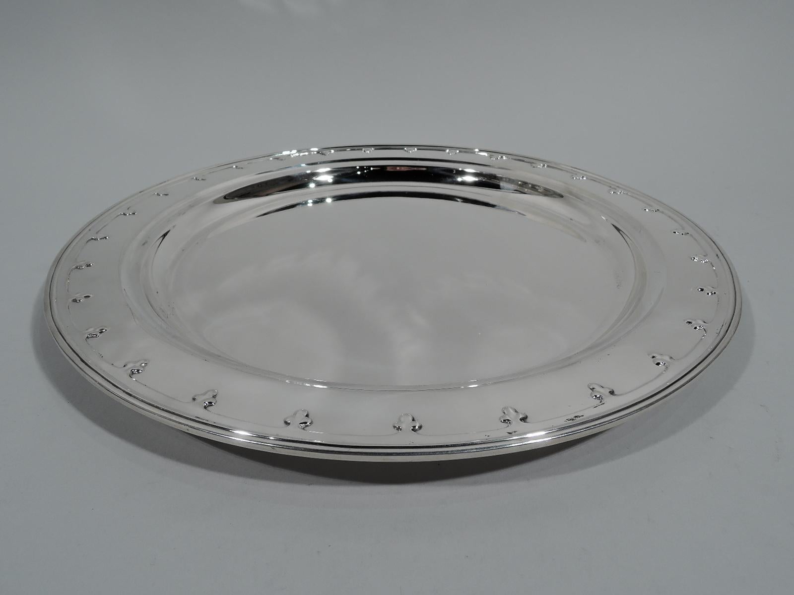 Saint Dunstan sterling silver tray. Made by Tiffany & Co. in New York, circa 1910. Round and deep well. Wide shoulder with applied fleur-de-lys border, and reeded rim. Fully marked including pattern no. 16471 and director’s letter m. Heavy weight: