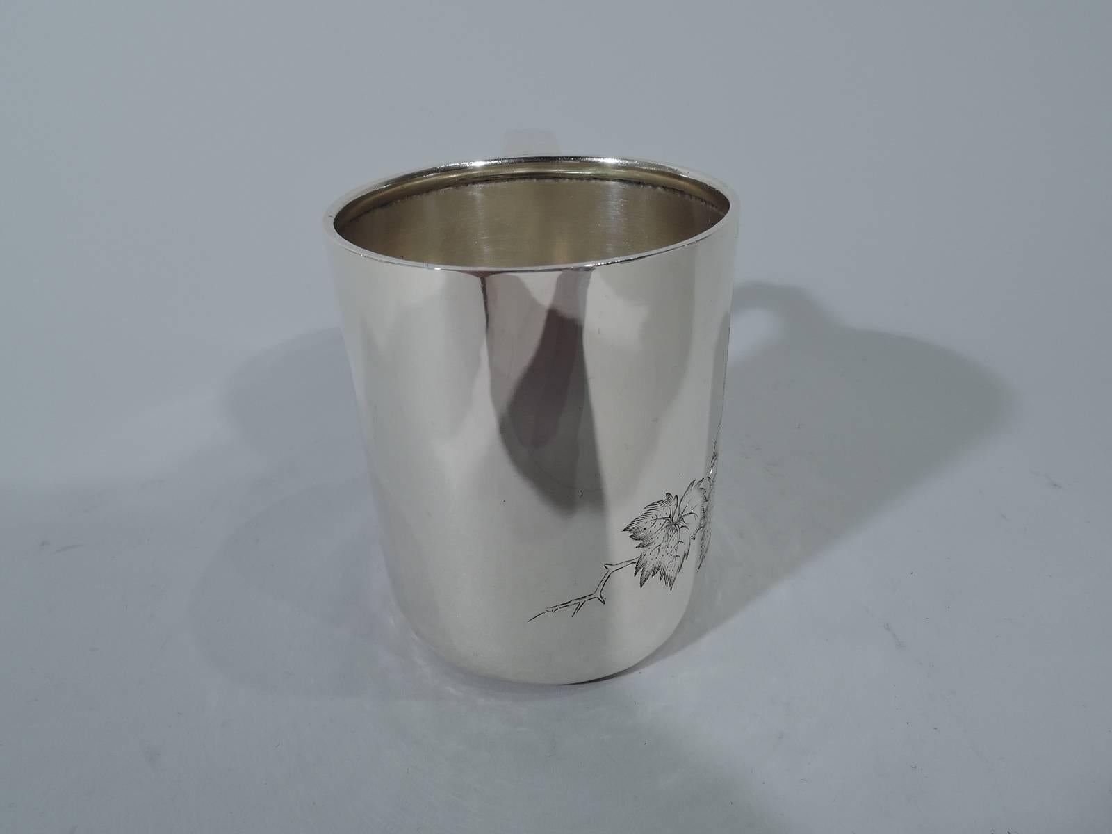 Sterling silver baby cup. Made by Tiffany & Co. in New York, circa 1875. Straight sides and scrolled bracket handle. On front is engraved fruiting berry branch with lush bunches. Back vacant. Hallmark includes pattern no. 4104 (first produced in