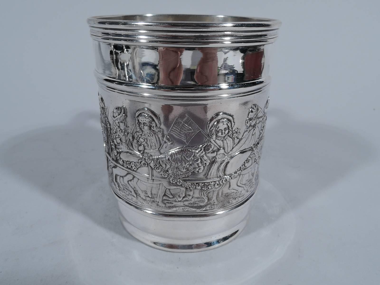 Sterling silver baby cup with patriotic parade. Made by Tiffany & Co. in New York. Dense and raised frieze with drum-beating, bugle-blowing, and flag-waving children. Some march and others ride in a garland-bedecked, pony-harnessed cart. Top and