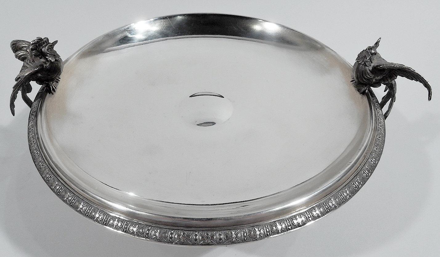 Klassisches Vogelbadkompott aus Sterlingsilber. Hergestellt von Tiffany & Co. in New York. Flache Schale mit umgedrehtem Rand und erhöhtem Fuß. Zwei gegossene Vogelfiguren mit üppigem Gefieder und extravaganten Kronen hocken auf dem Schalenrand,