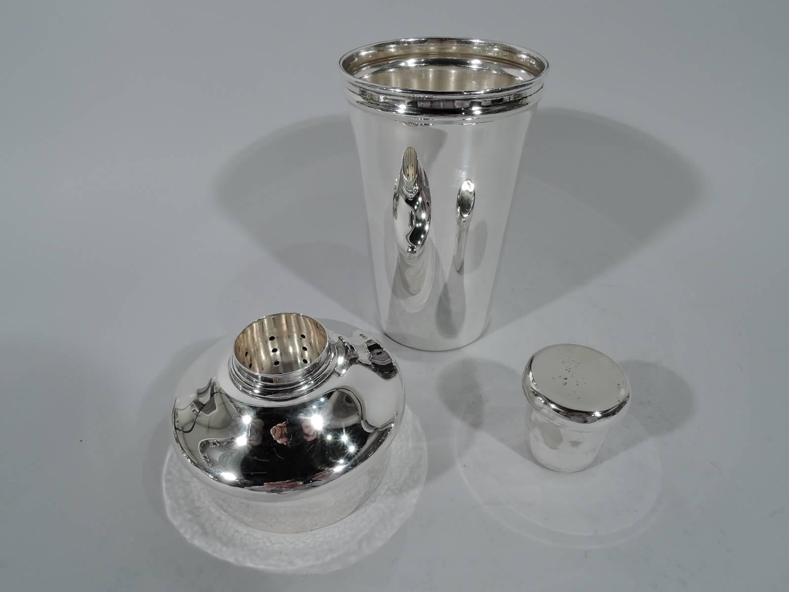 Sterling silver cocktail shaker. Made by Tiffany & Co. in New York, ca 1915. Cup has straight and tapering sides. Bellied and domed top with central built-in strainer and plug. Innovative and functional. Hallmark includes pattern no. 18917 (first