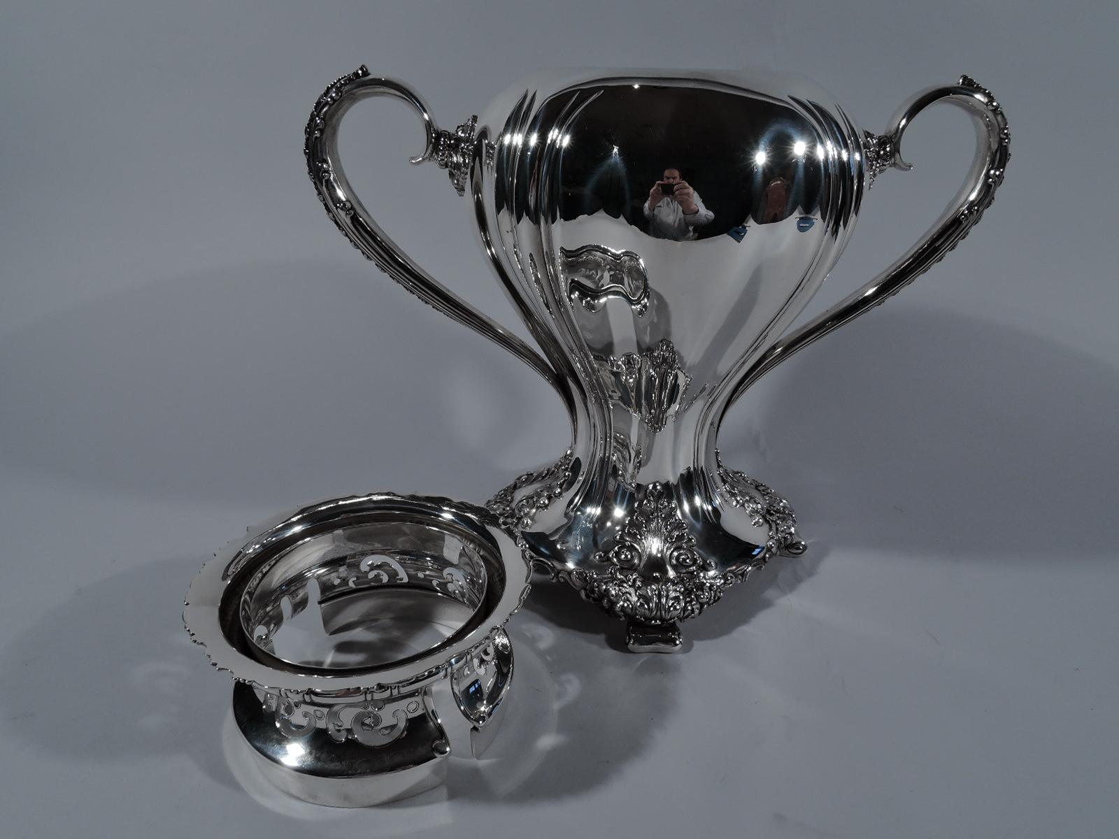 Heavy Classical sterling silver trophy cup. Made by Tiffany & Co. in New York. Swooping baluster flowing into four curved-sided base on splayed volute supports. Leaf-capped and mounted reeded scroll side handles. Slash gadrooning. Acanthus leaves