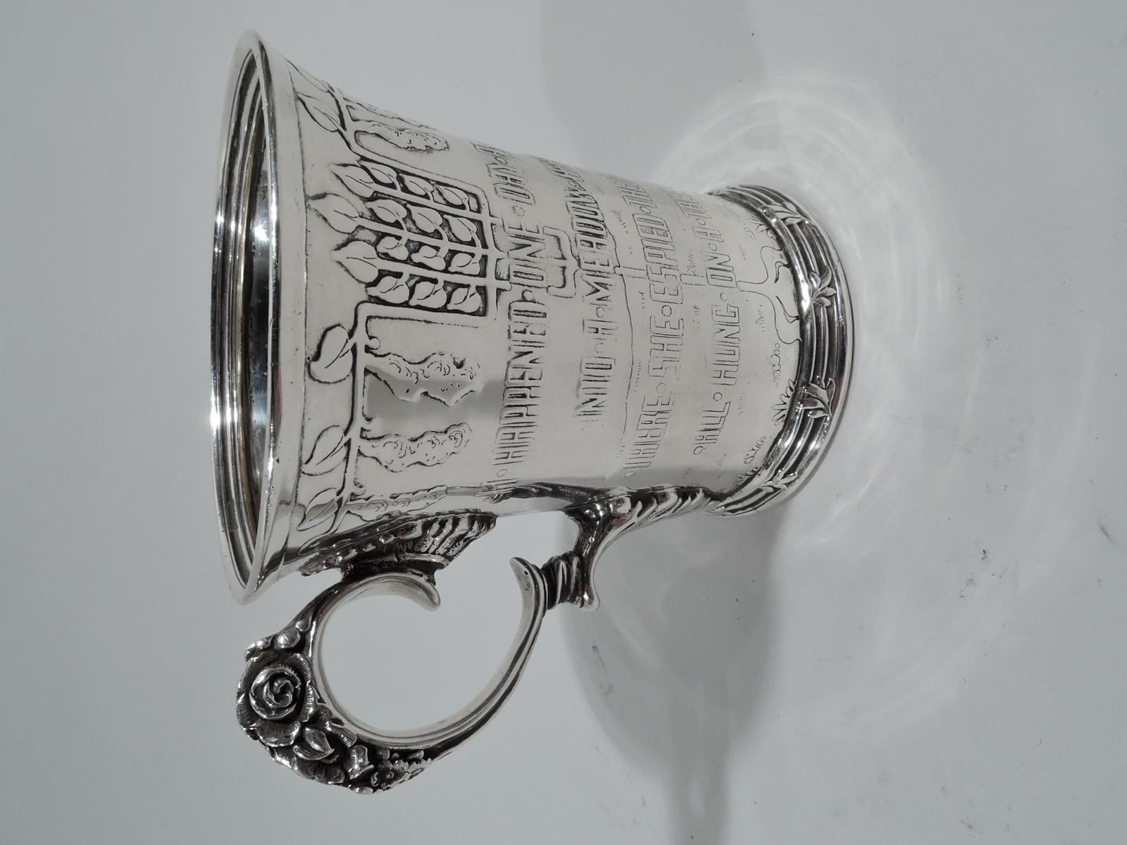 Edwardian Art Nouveau sterling silver baby cup. Made by Tiffany & Co. in New York, and imported to England in 1902 by Albert William Feavearyear in London. Tall bowl with flared rim, reeded base, and flower-capped scroll handle with leaf mounts.