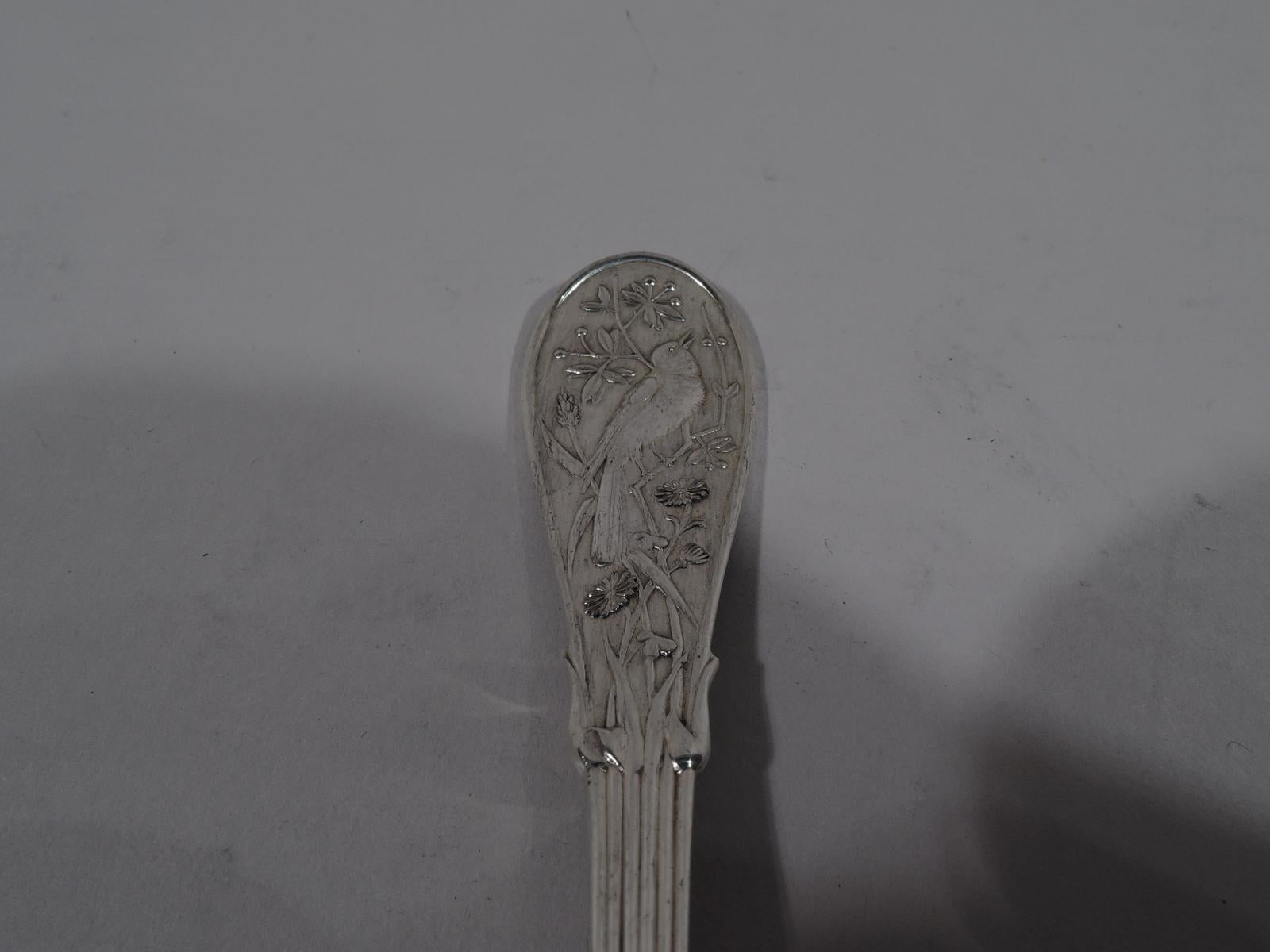 Japanese sterling silver master butter. Made by Tiffany & Co. in New York. Flat handle with double-sided reeding that terminates in flower stems on terminal. On terminal front is perched bird. Terminal back vacant with flower on heel. Blade has