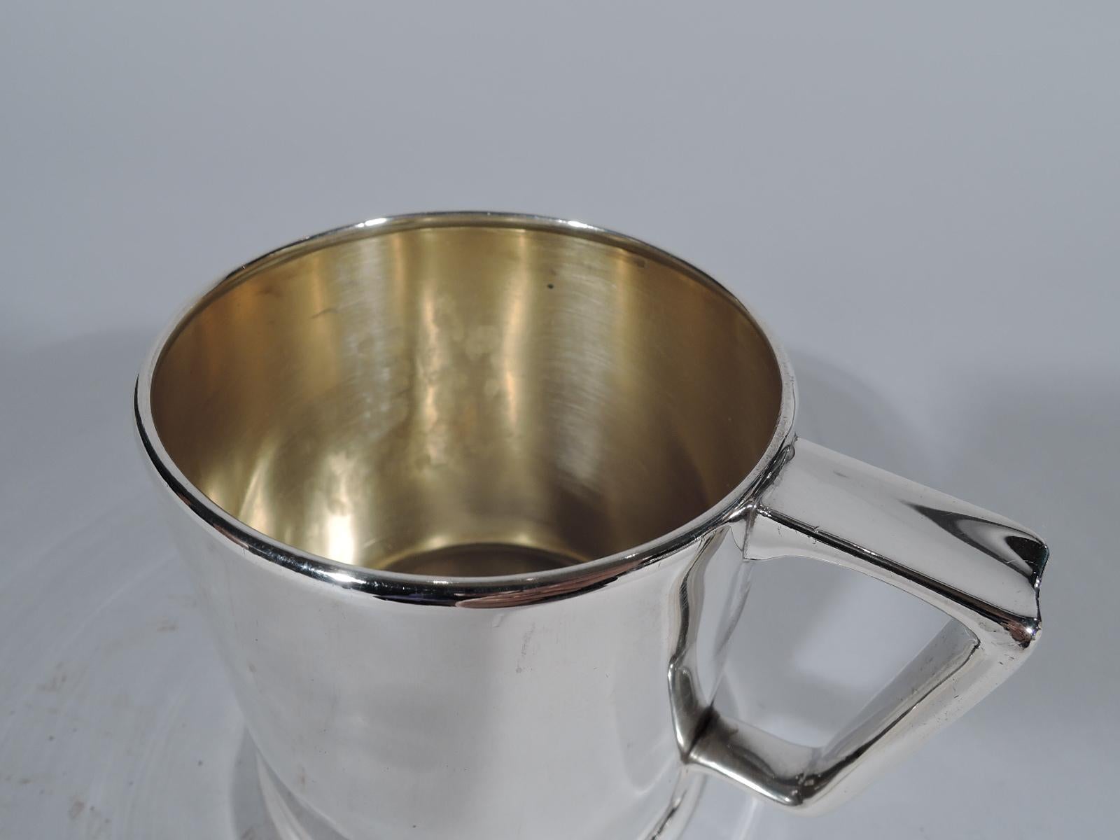 Spare and elegant sterling silver baby cup. Made by Tiffany & Co. in New York, circa 1907. Drum form with bracket handle and skirted foot. Interior gilt washed. Nice heft with lots of room for engraving. Fully marked including pattern no. 17093