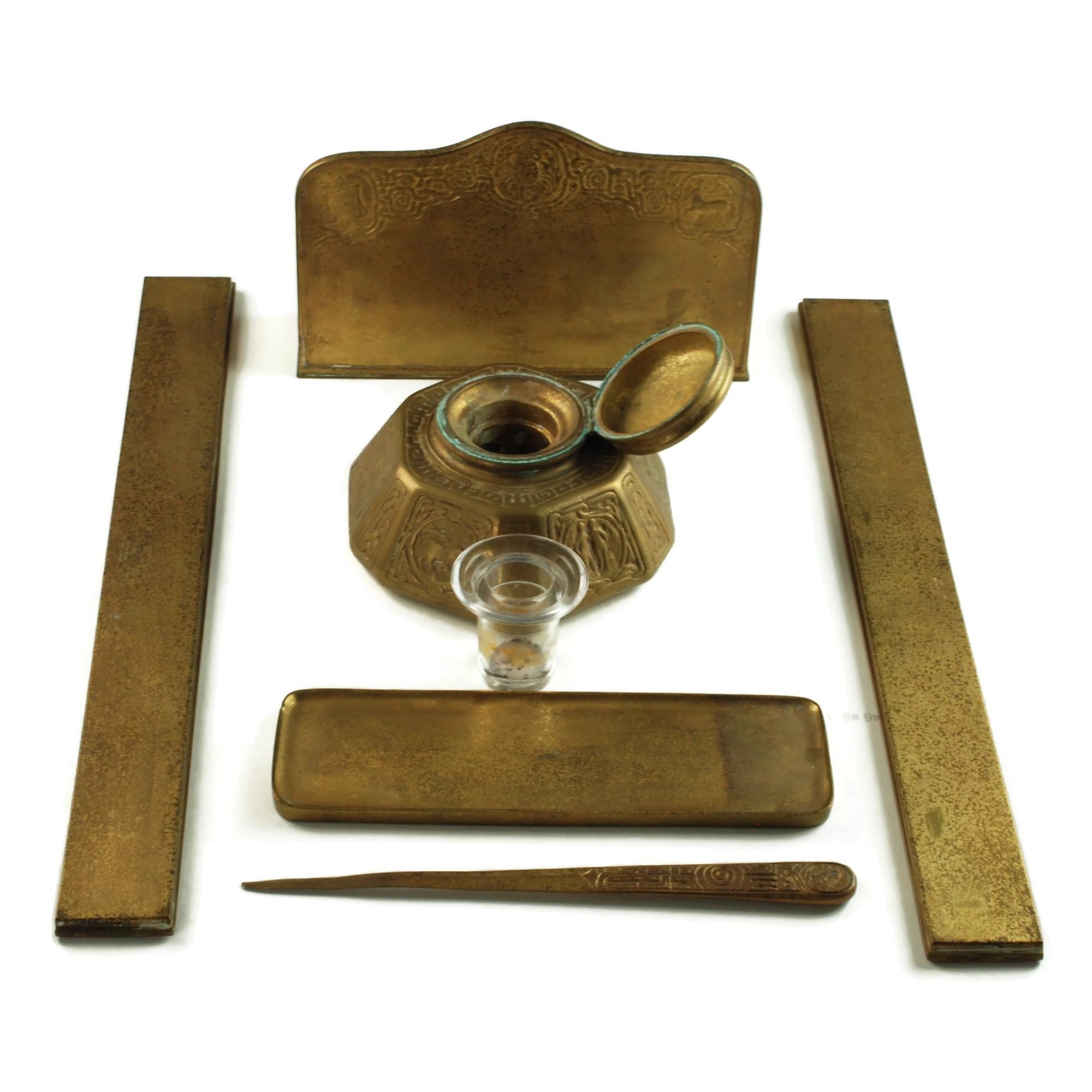 This lovely 6-piece bronze doré desk set was made by Tiffany Studios of New York.  The early 20th-century set has a warm golden finish with its original patina and has been made in Tiffany's popular Zodiac motif featuring stylized depictions of the