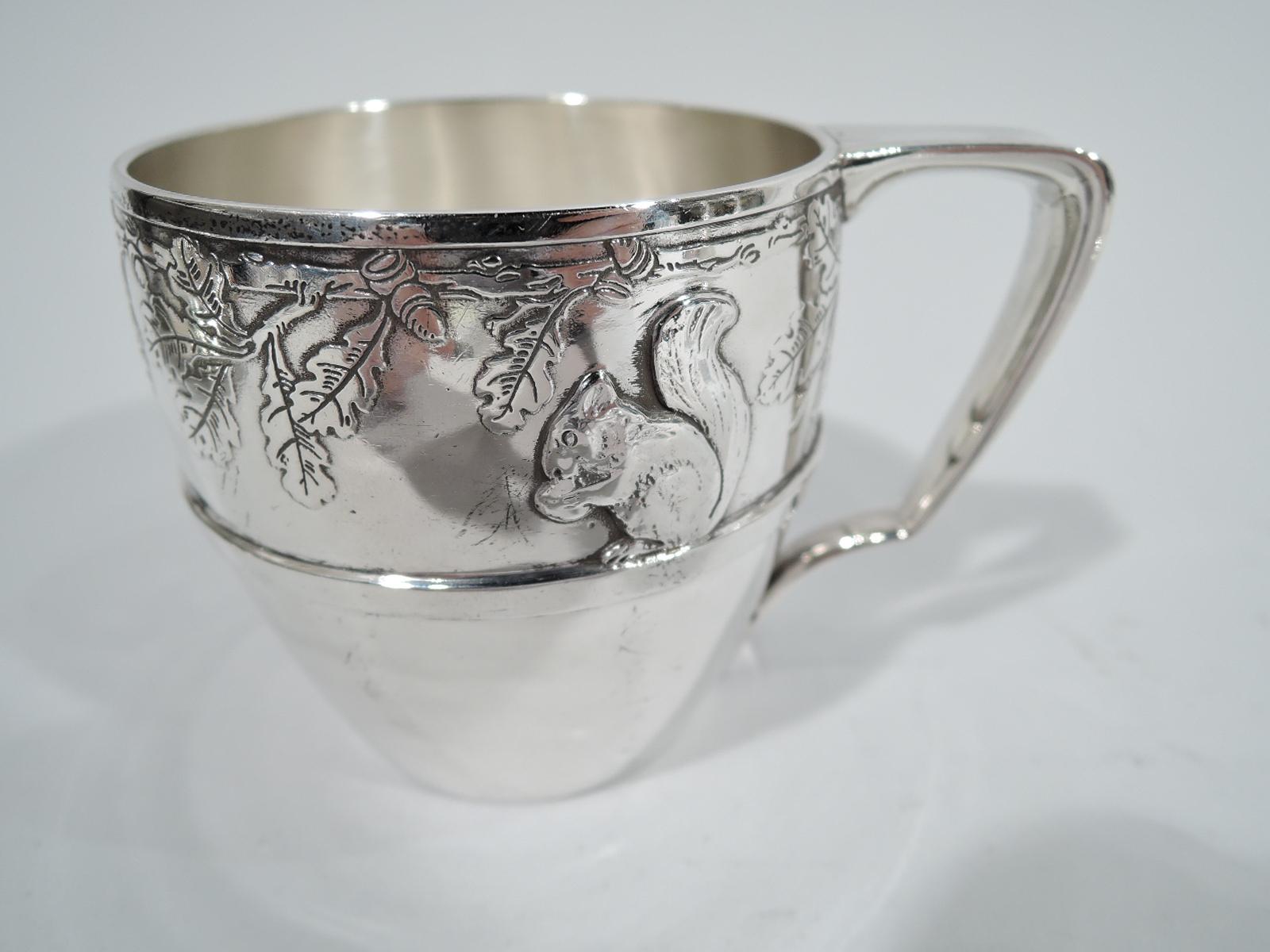 Art Deco sterling silver baby set. Made by Tiffany & Co. in New York, circa 1927. This set comprises 9 pieces: cup, bowl, plate, napkin ring, knife, 2 spoons, fork, and food pusher. Each piece has acid-etched frieze with alternating oak leaves and