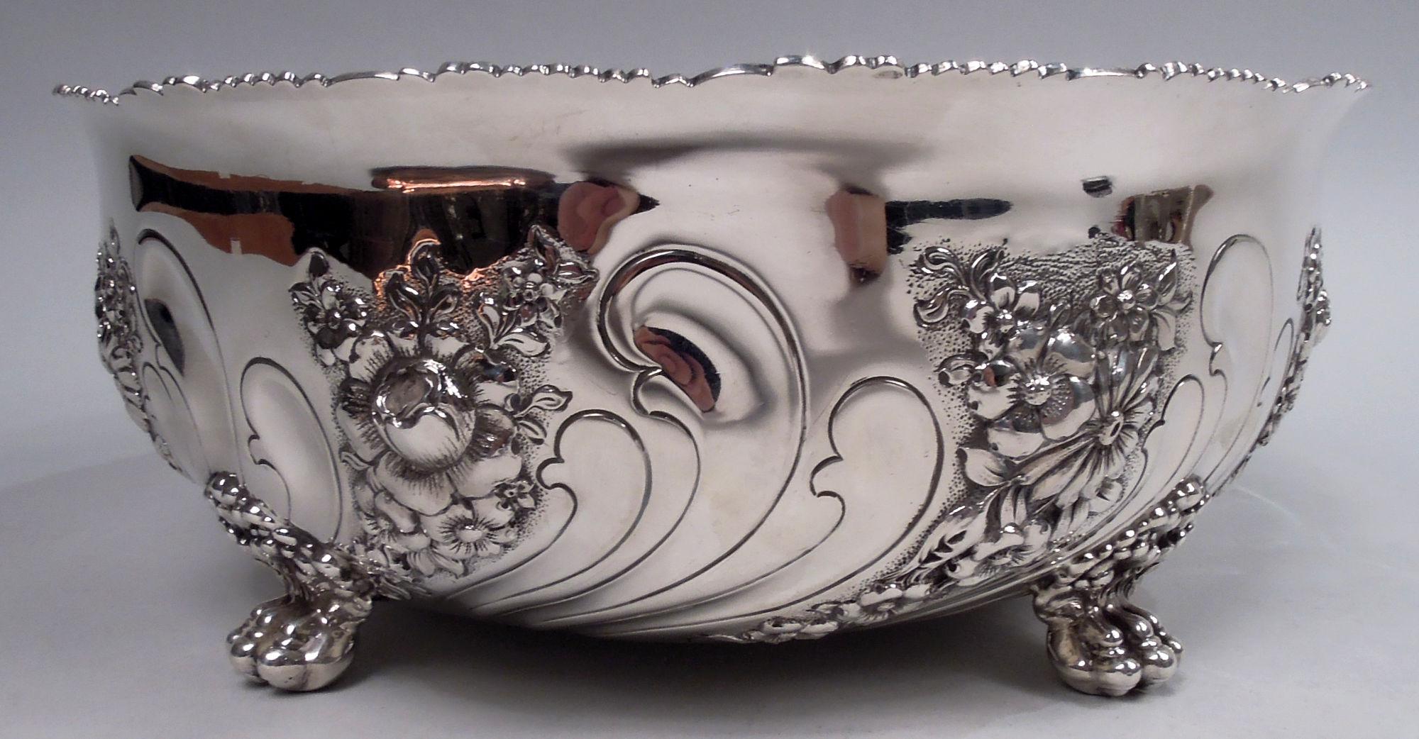 Victorian Classical sterling silver bowl. Made by Tiffany & Co. in New York. Curved sides with chased twisted flutes alternating with repousse floral ones. Cast interior rim comprising alternating ferns and flower heads. Four leafing scroll-mounted