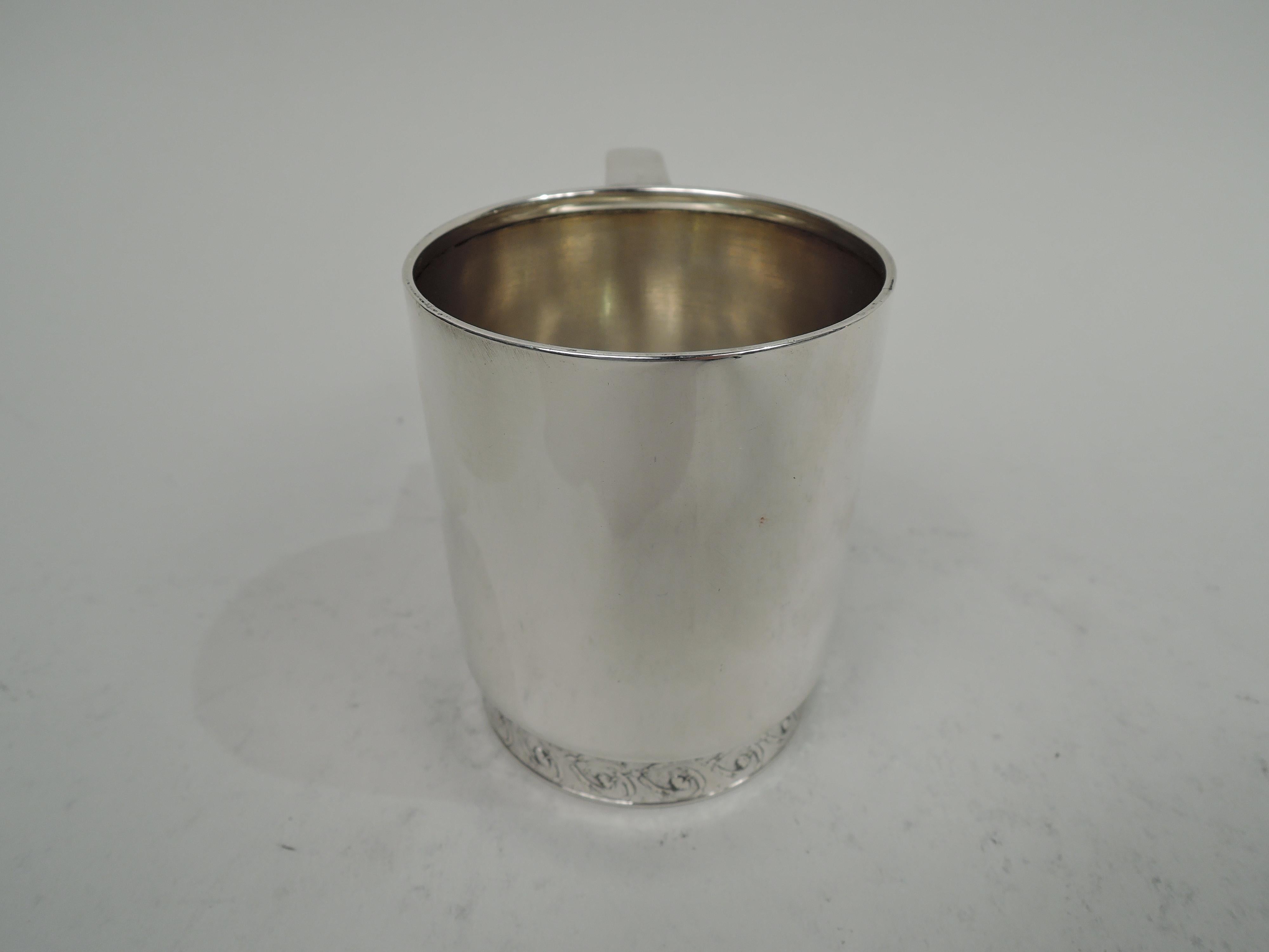 Victorian Classical sterling silver baby cup. Made by Tiffany & Co. in New York. Straight sides and scroll bracket handle. Short and inset foot with acid-etched flowering rinceaux border. Stylish and restrained with lots of room for engraving. Fully