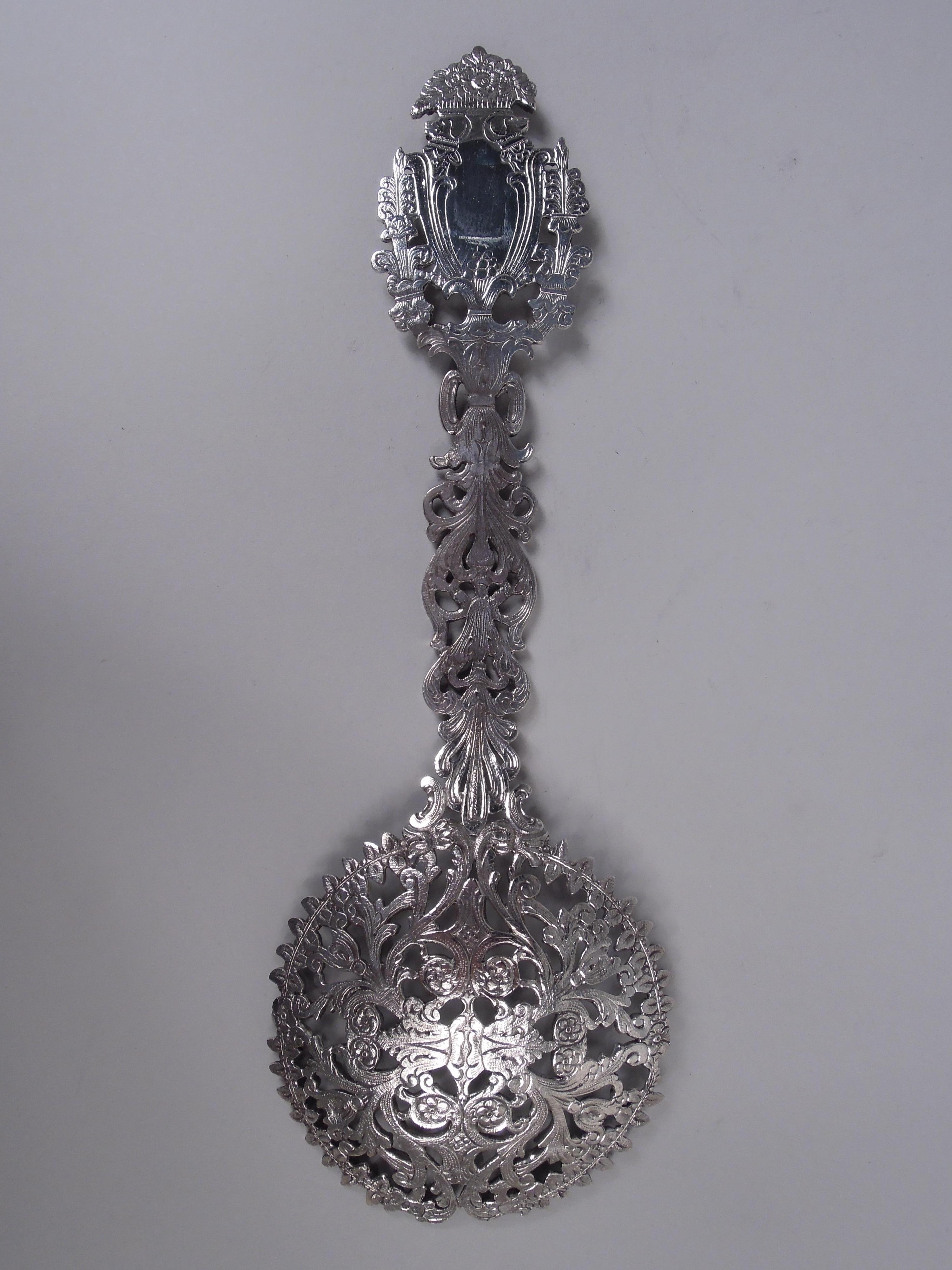 Paletta classica vittoriana in argento sterling. Prodotto da Tiffany & Co. a New York, 1910 circa. Ciotola rotonda e poco profonda e manico sagomato. Volute aperte e incise; cartiglio a volute (libero) che termina con un cesto di fiori.