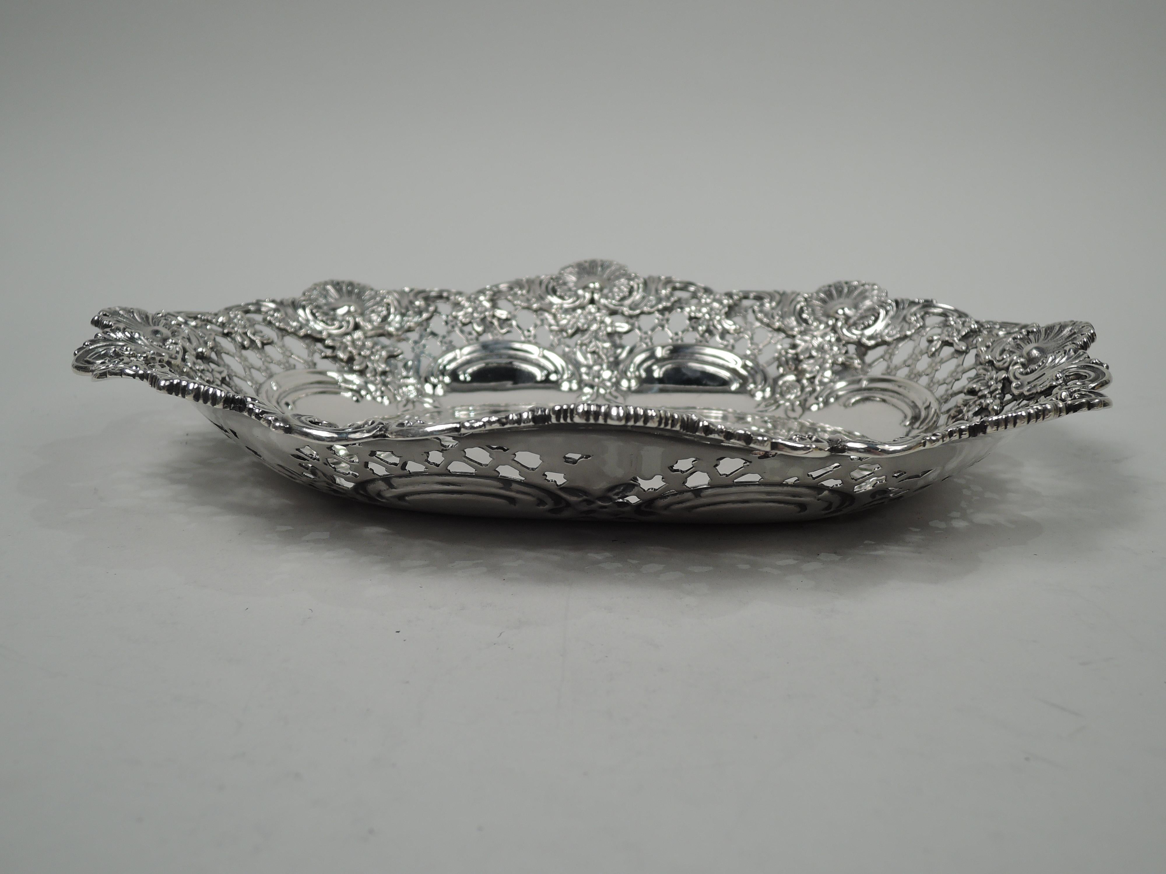 Victorian Classical sterling silver bowl. Made by Tiffany & Co. in New York. Solid oval well with chased scalloped border. Sides tapering open diaper and applied pendant flowers. Dim has applied scallop shells alternating with could c-scrolls. Fully