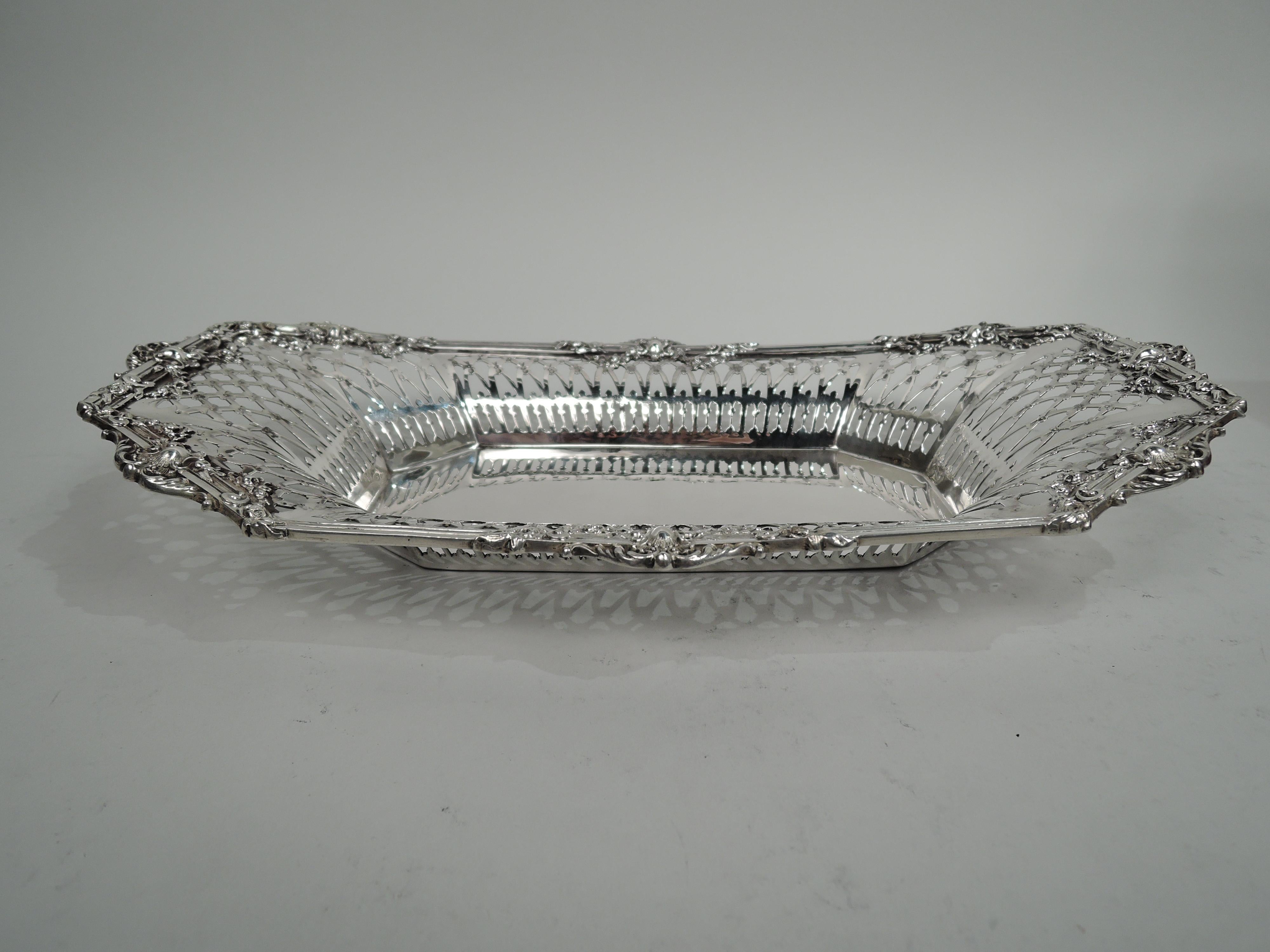 American Victorian Classical sterling silver bread tray, ca 1890. Retailed by Tiffany & Co. in New York. Solid rectangular well with chamfered corners. Tapering sides with open colonnade and diaper. Reeded rim with tapering and concave corners, and
