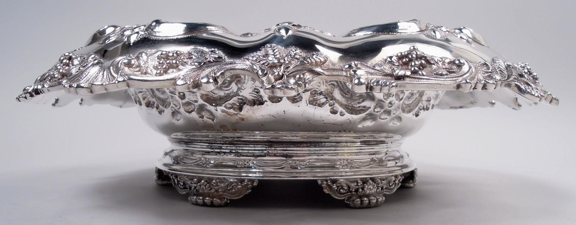 Victorian Classical sterling silver bowl. Made by Tiffany & Co. in New York. Round and solid well. Tapering sides with chased and engraved ornament: alternating flowers and open floral diaper in leafing-scroll frames. Turned down rim applied with