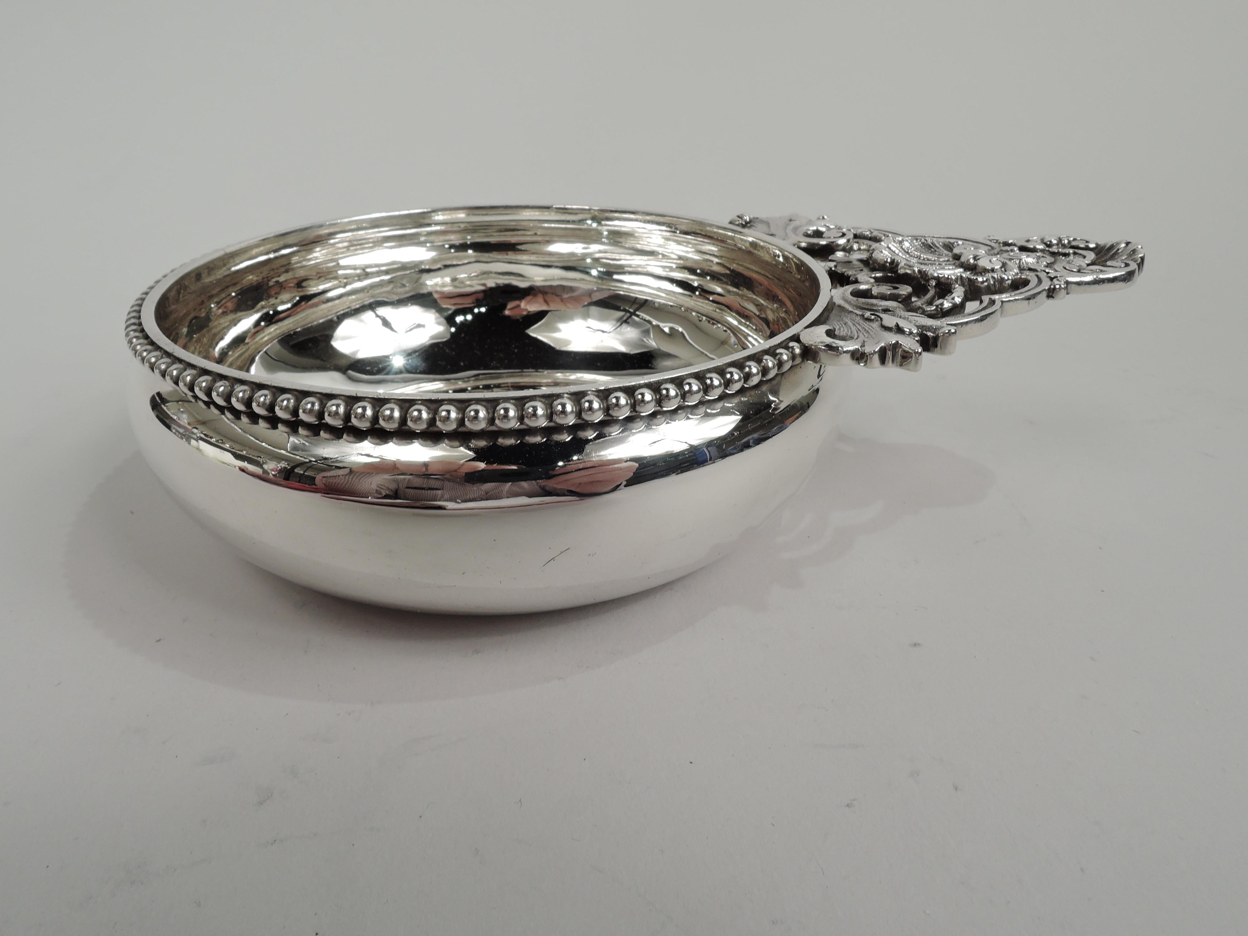 Victorian classical sterling silver porringer. Made by Tiffany & Co. in New York. Bowl has curved sides and rim applied with bold beading. Leaf-mounted open scroll handle with scallop shells. Fully marked including maker’s stamp, pattern no. 12755,
