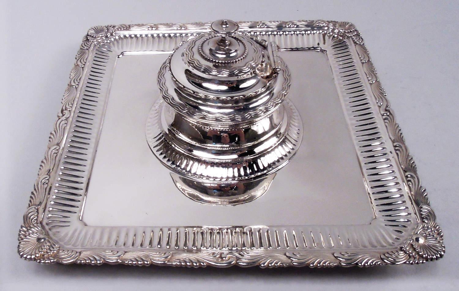 Wave Edge sterling silver inkstand. Made by Tiffany & Co. in New York, ca 1884. Square with corner scroll-mounted supports. Centrally mounted bowl with hinged cover. Applied reeded and overlapping scrolls as well as wavy, fluting, and beading. Fully