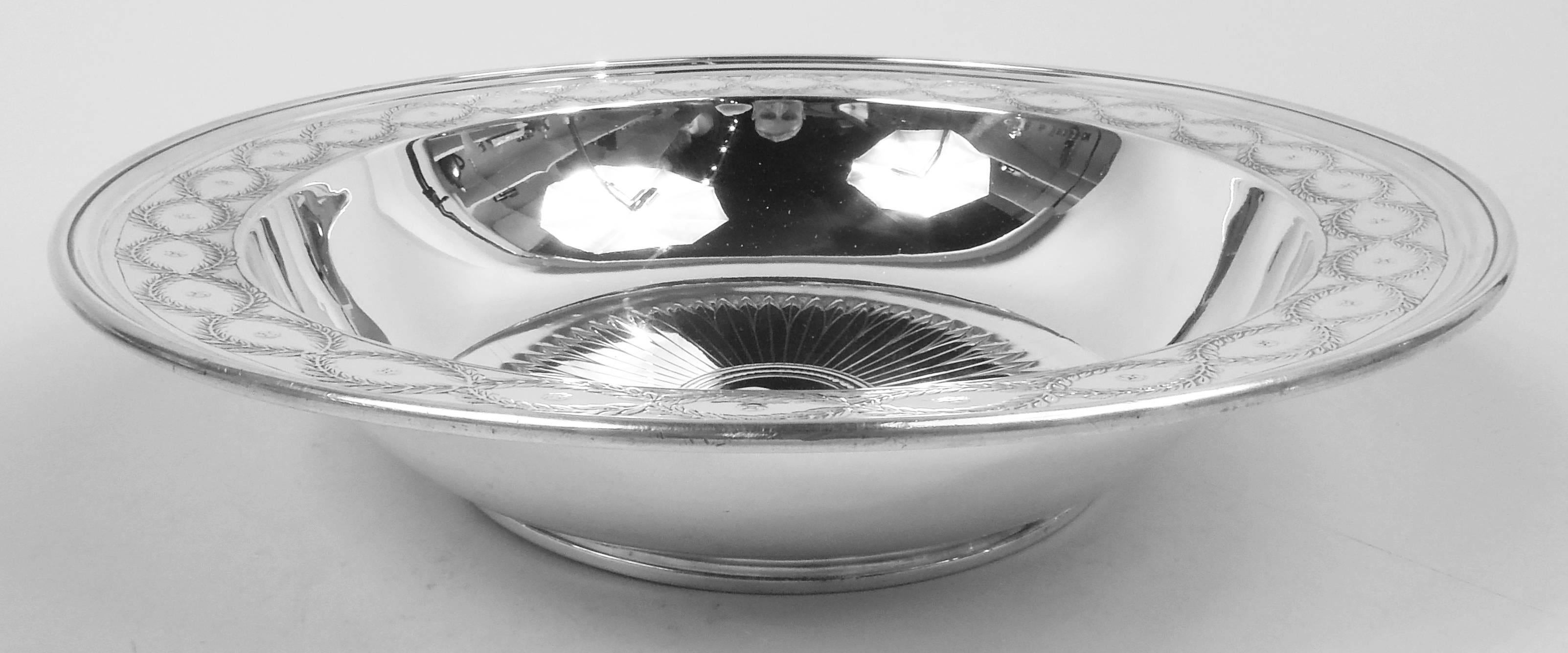 Winthrop sterling silver bowl. Made by Tiffany & Co. in New York, ca 1922. Curved sides and gently tapering shoulder with reeded rim; stepped foot ring. Acid-etched ornament. In well is patera comprising beaded rondel (vacant) radiating