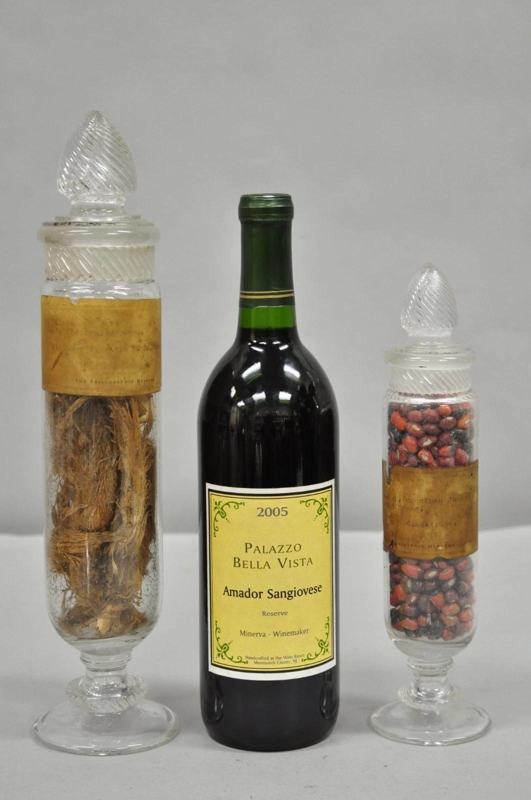 Pots à bonbons anciens en verre Dakota de Tiffin avec bouchons à spirale et contenu provenant du Musée de Philadelphie avec des restes d'étiquettes d'origine - ensemble de 2 pièces. Circa Early 20th Century. Mesures : Grand : 13,5