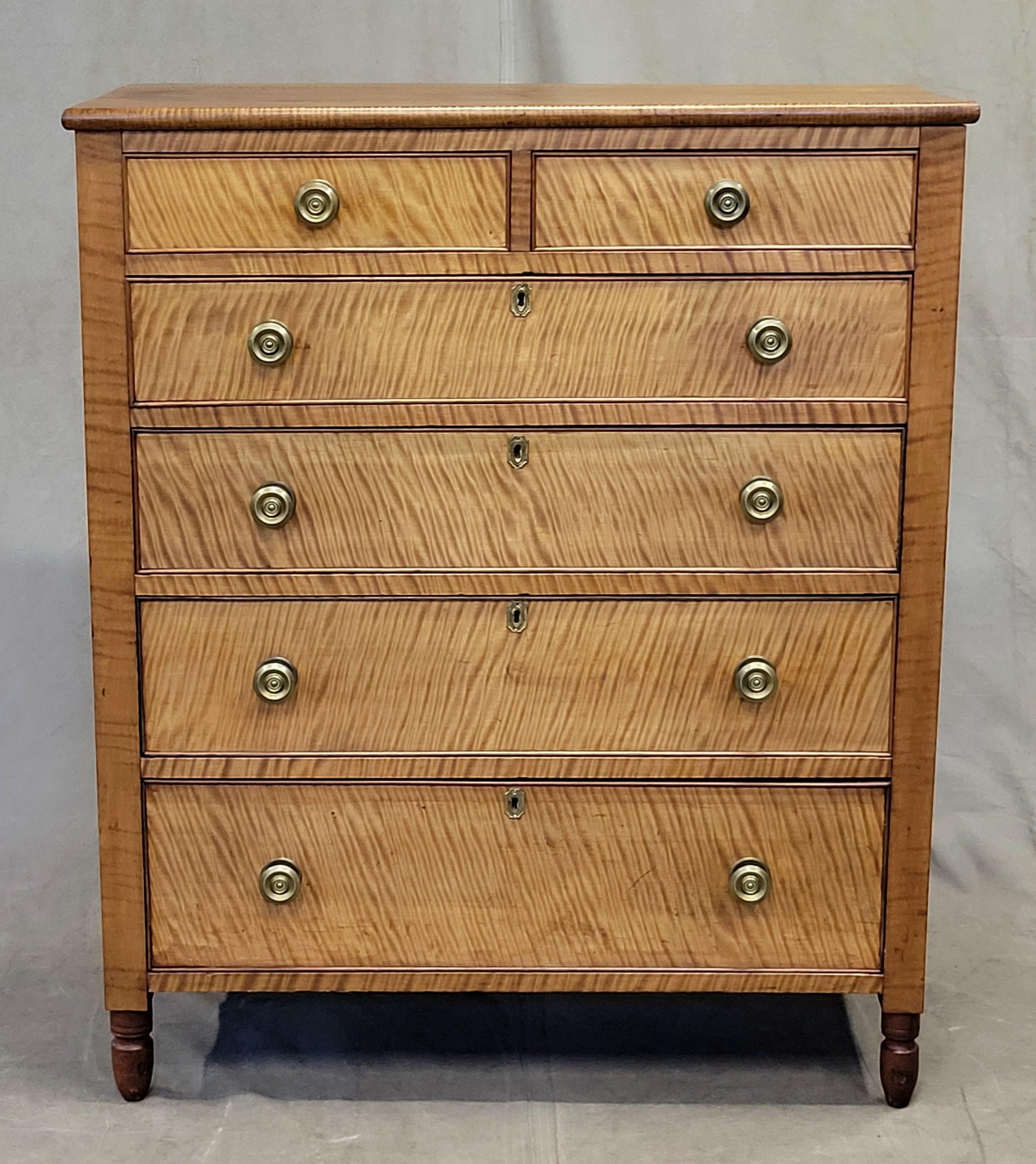 An absolutely stunning antique American Sheraton (1820s or 1830s) tiger maple chest of drawers dresser with original brass hardware. Drawers are tiger maple trimmed in mahogany and dresser framework is cherry. Gorgeous woodgrain while offering a