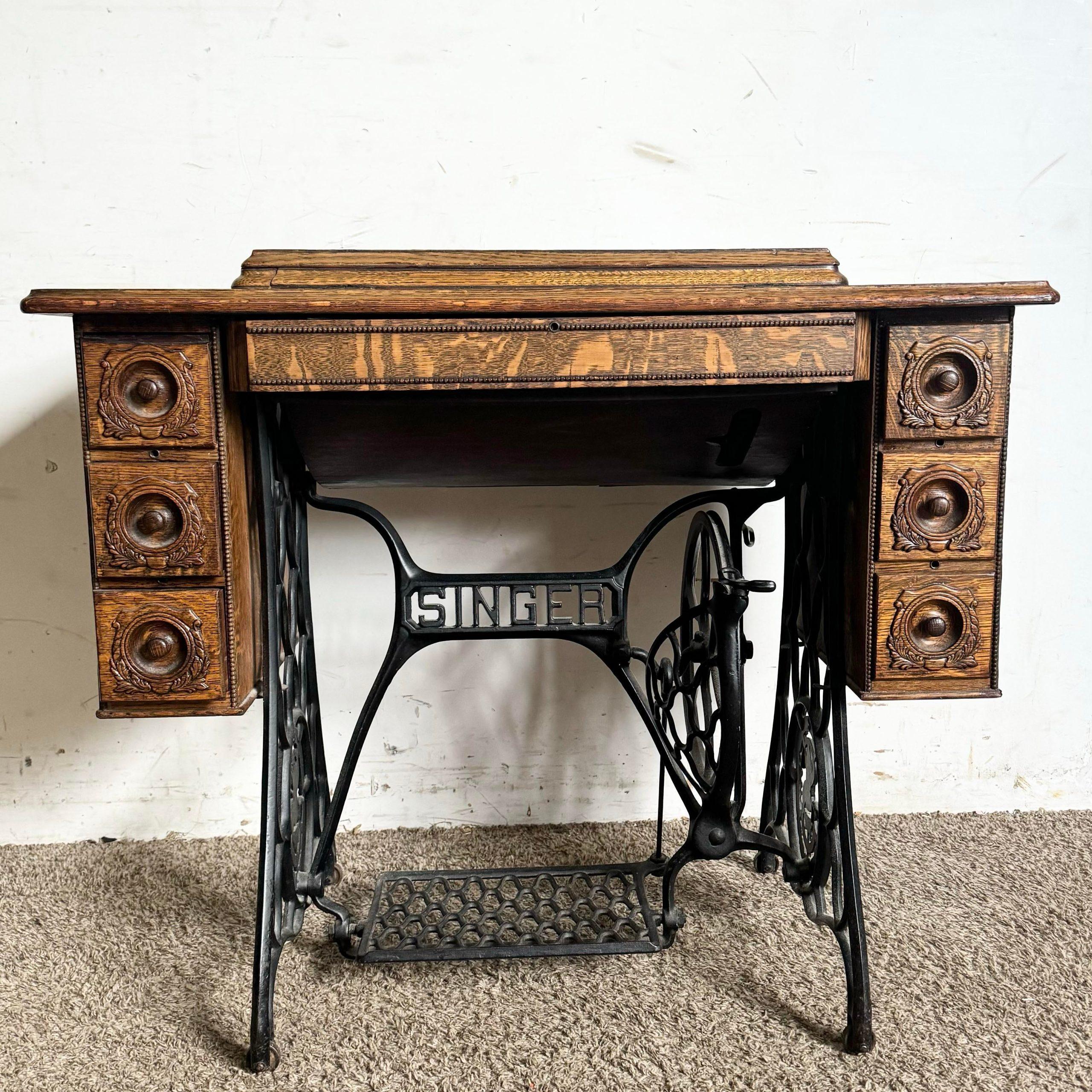 This antique Singer sewing machine table, crafted from tiger oak and featuring wrought iron detailing, is a stunning blend of vintage charm and functionality. The rich tiger oak grain and sturdy wrought iron base capture the timeless appeal of early