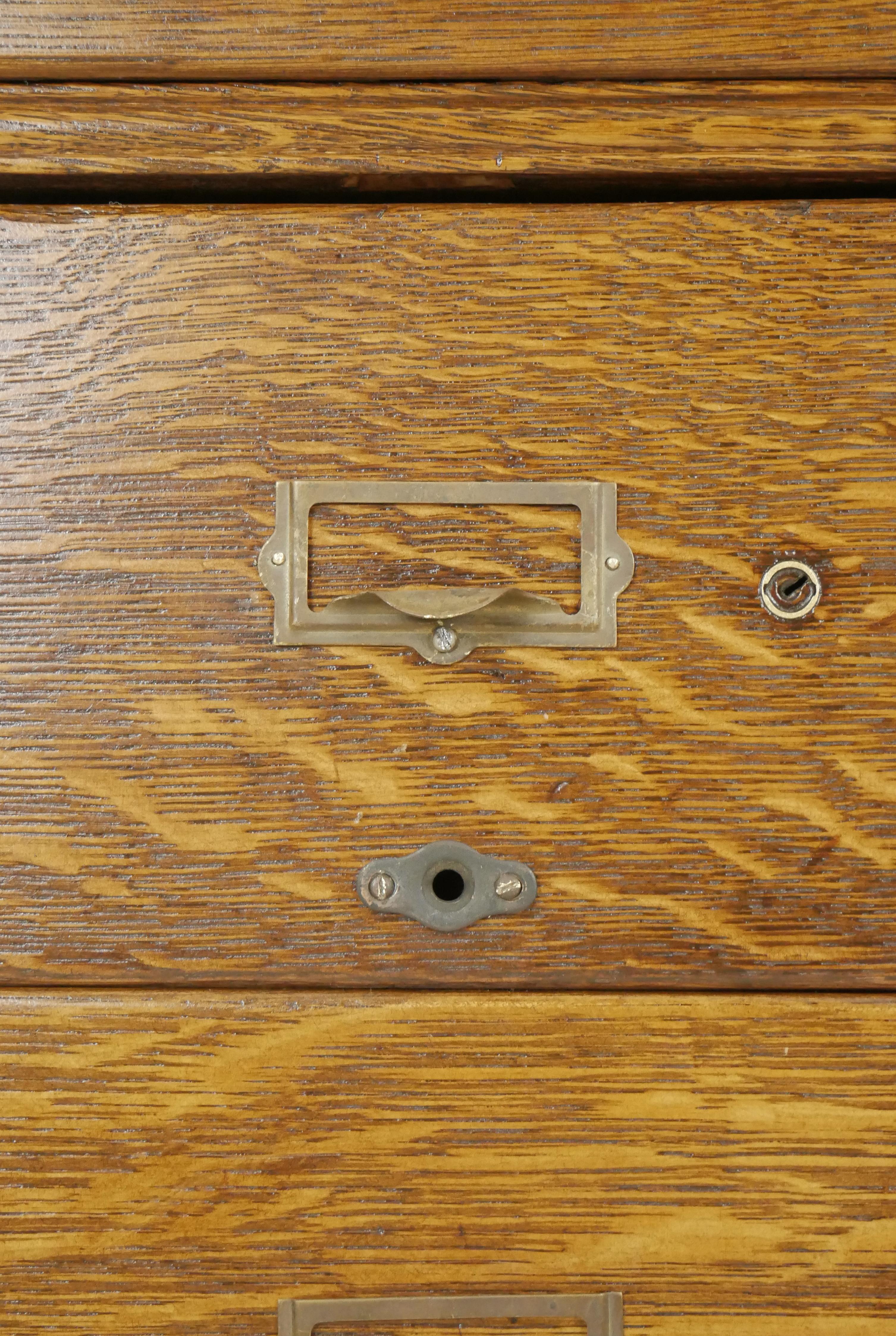 Antique card catalog cabinet with 15 dovetailed drawers in three stackable pieces. Each drawer has a brass drawer label slot pull. Good condition with surface wear from prior use. One available. Please note, this item is located in one of our NYC
