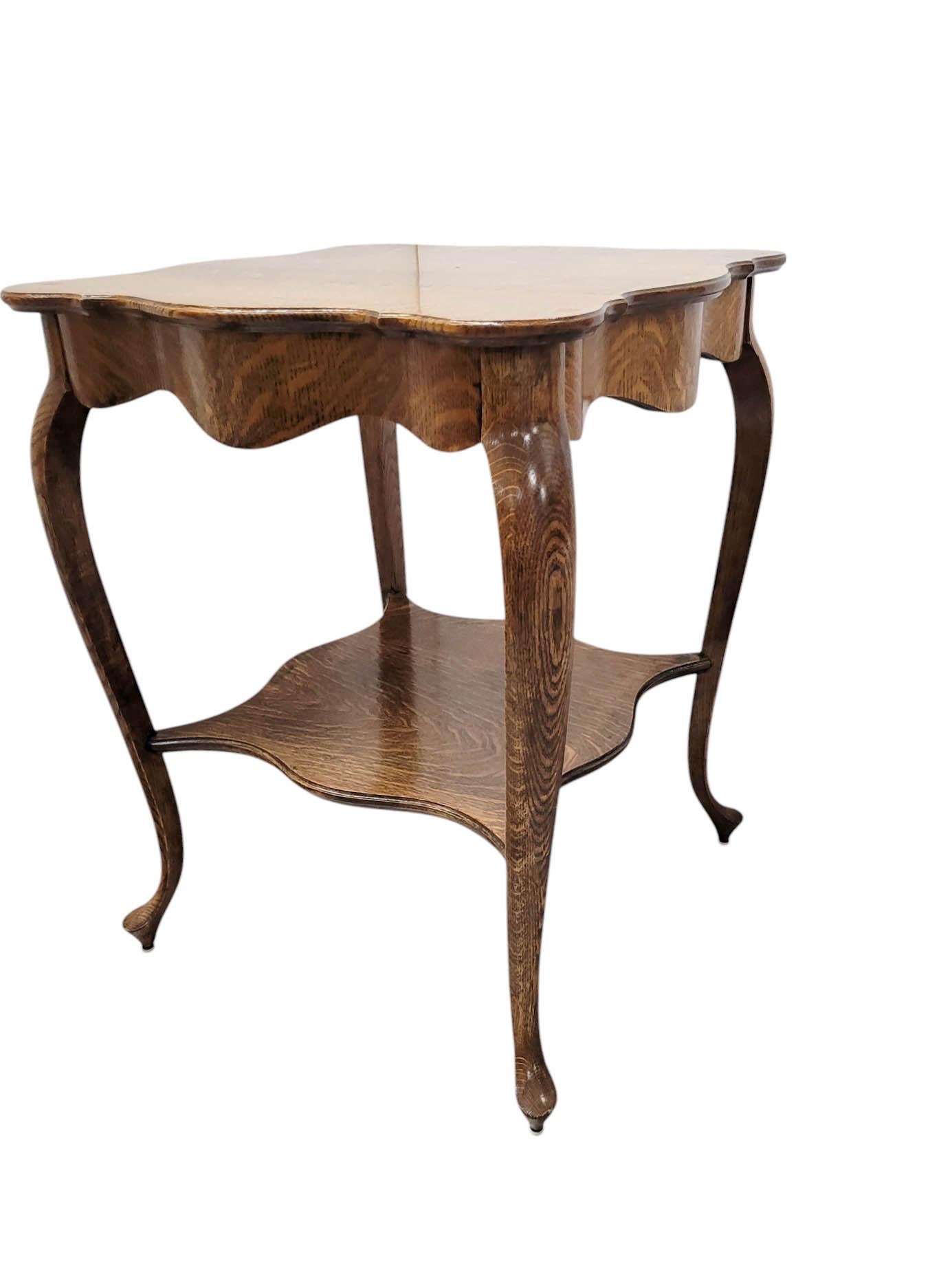 Step into the warmth of early 20th-century design with this charming antique parlor table, crafted from quarter-sawn oak. This particular cut of oak reveals a striking, wavy grain pattern often referred to as 