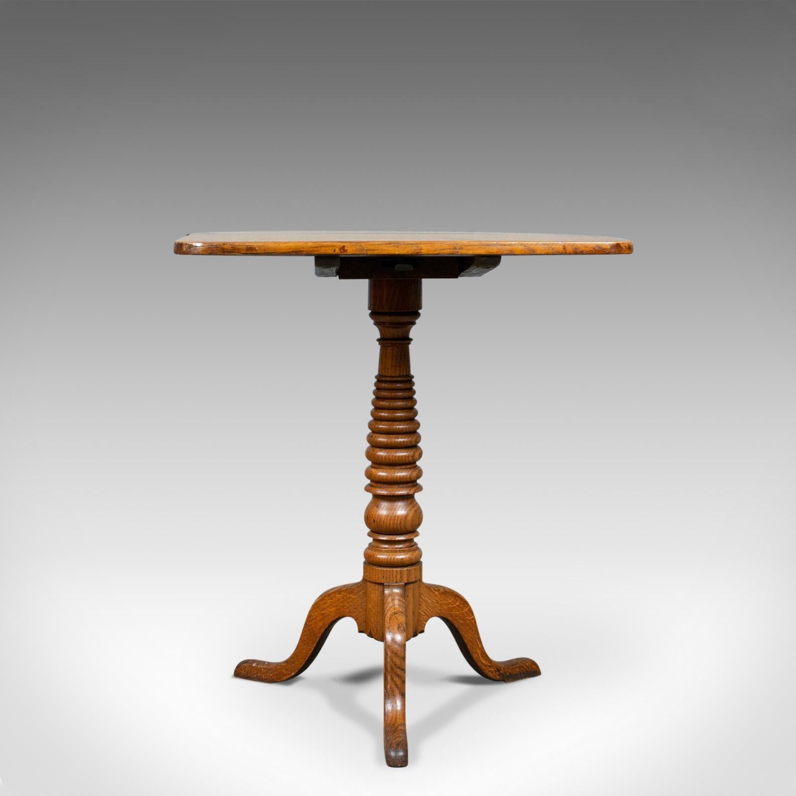 This is an antique tilt-top table. An English, Victorian, oak side table dating to the mid-19th century, circa 1870.

Golden oak displaying good grain detail with wisps of medullary rays
Deep, rich tones with a desirable aged patina
Planked top